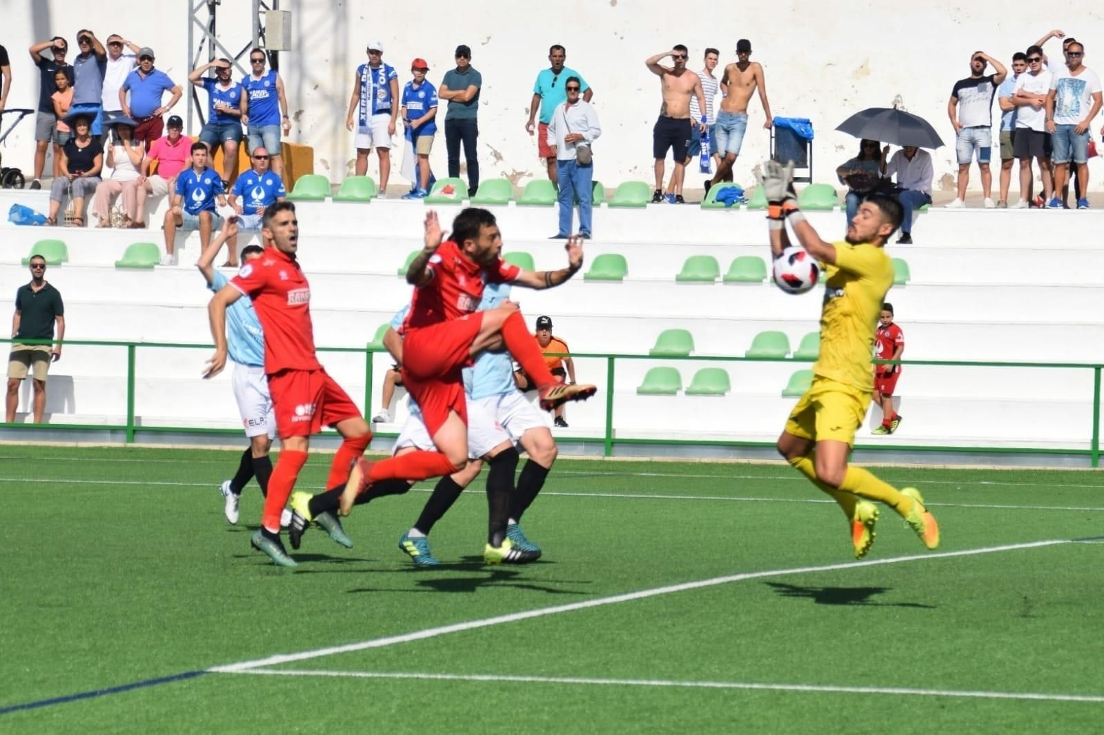 Iván Ares, portero jerezano de la Lebrijana, tapona el remate de Adrián Gallardo en el choque de ayer.