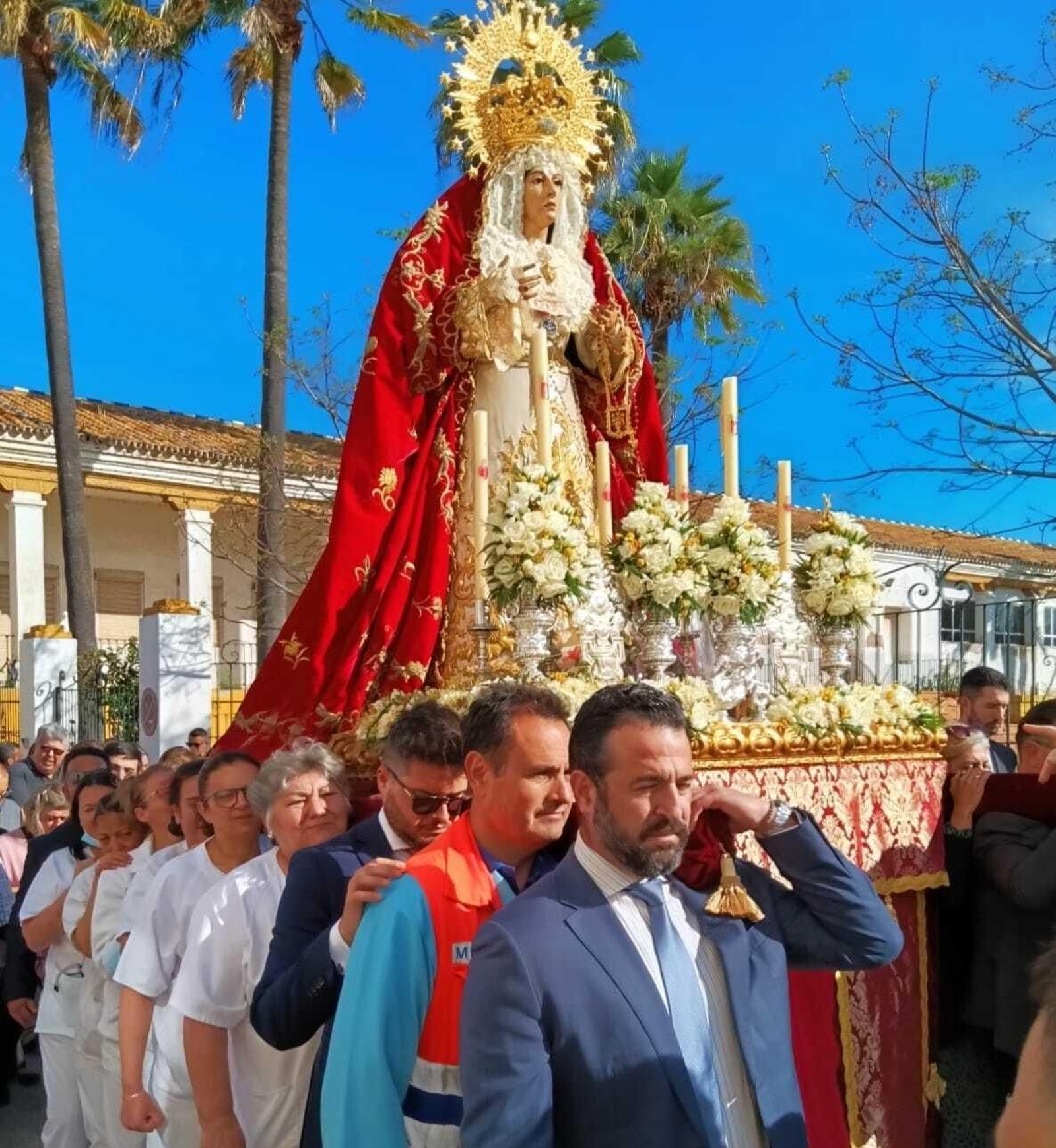 Sanitarios portan en andas a la Virgen de Amor y Sacrificio de la Hermandad de Santa Cruz.