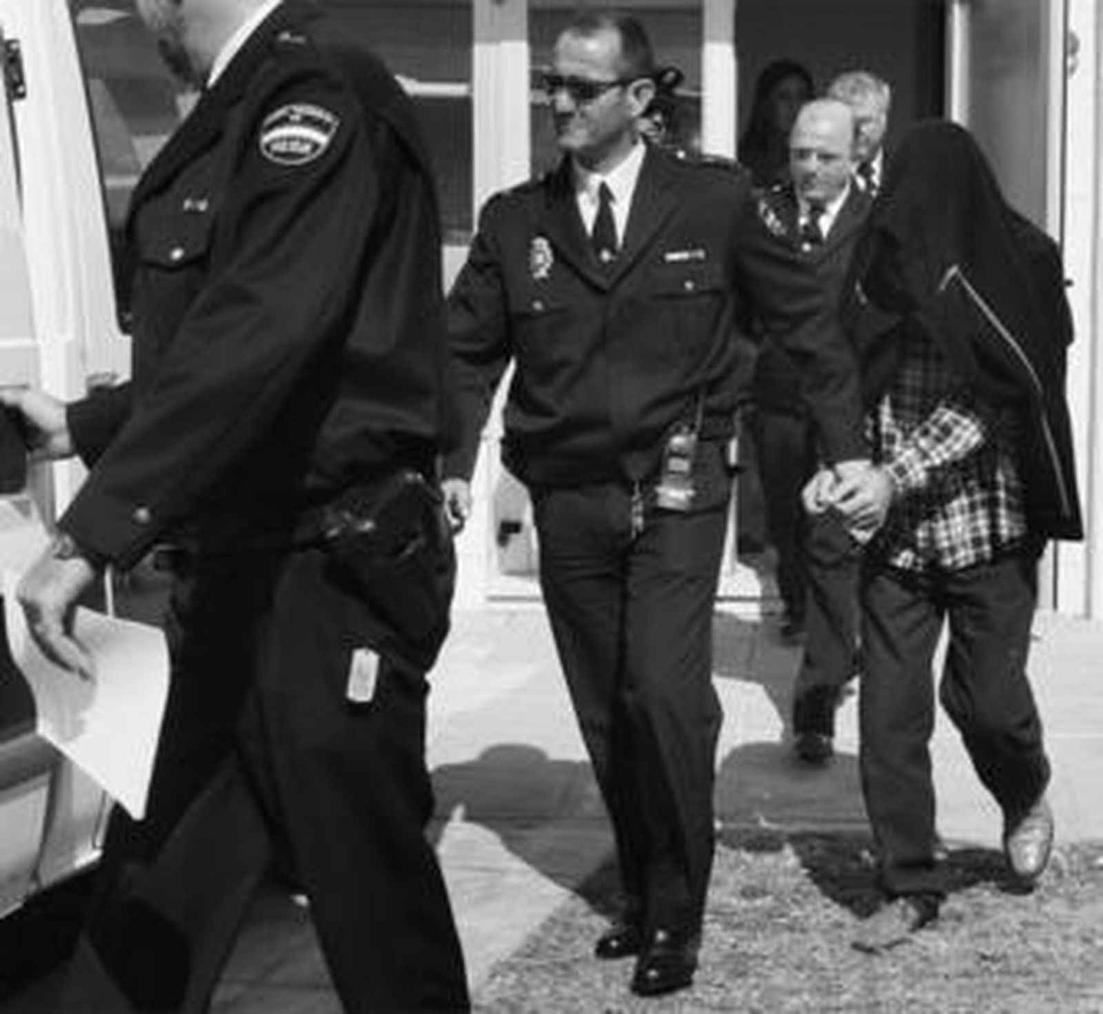 Policías Nacionales escoltan al detenido hacia el furgón que lo llevaría hasta la prisión.