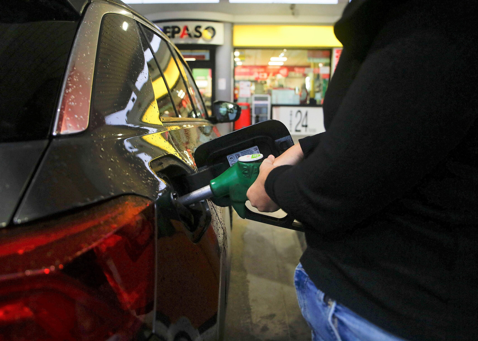 Un conductor echa combustible en su vehículo.