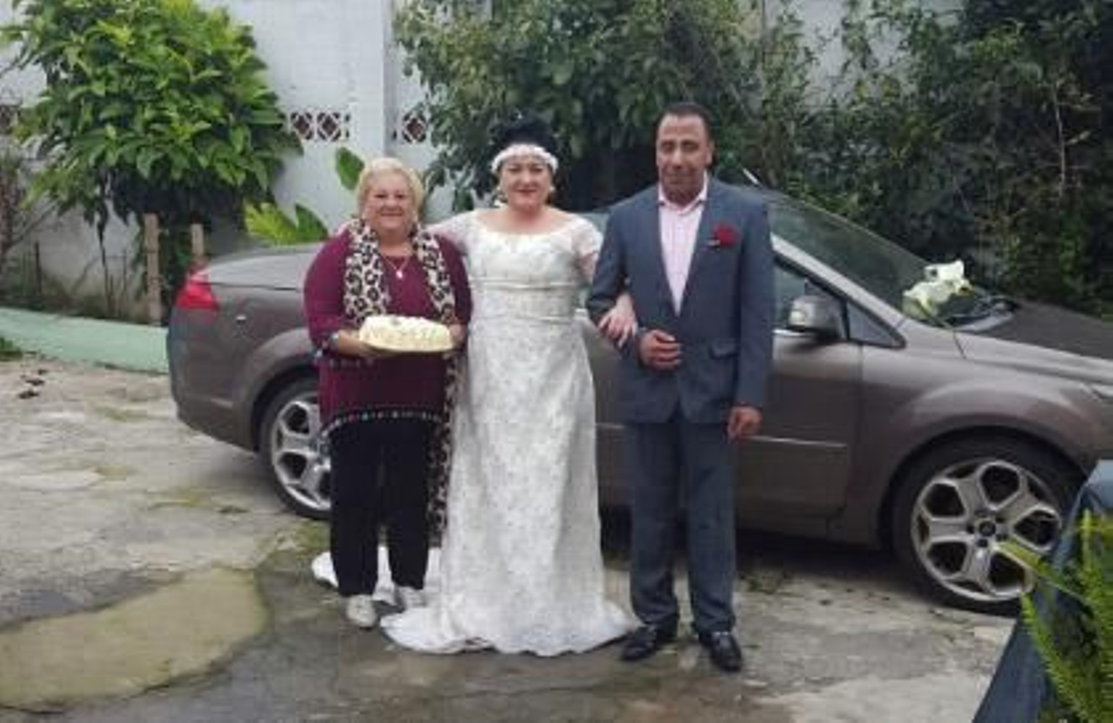 Los novios, junto a la madre de la novia, con su tarta de cumpleaños en las manos