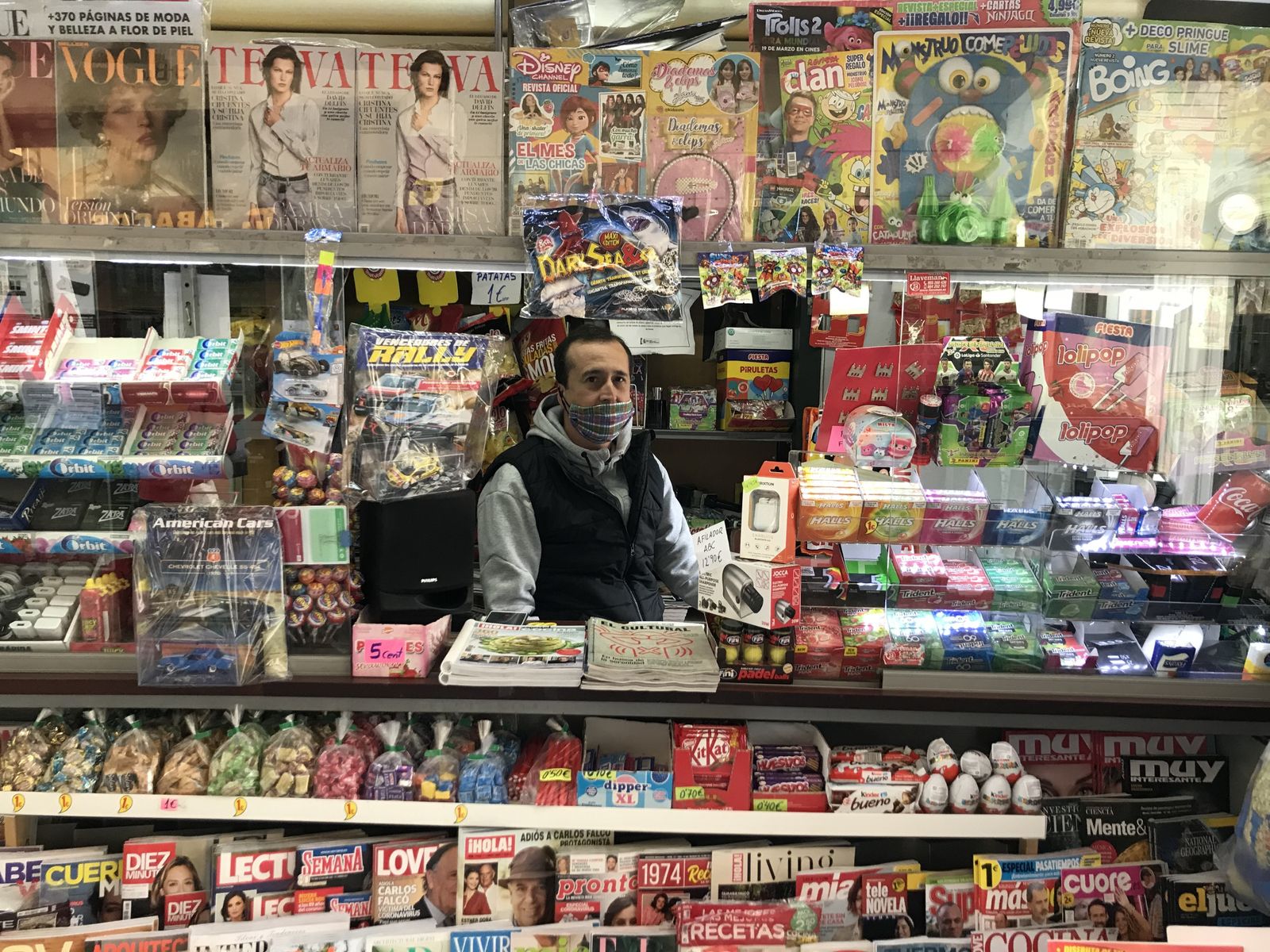 Ricardo,  con guantes y mascarilla, en el kiosko de prensa de la Alfalfa