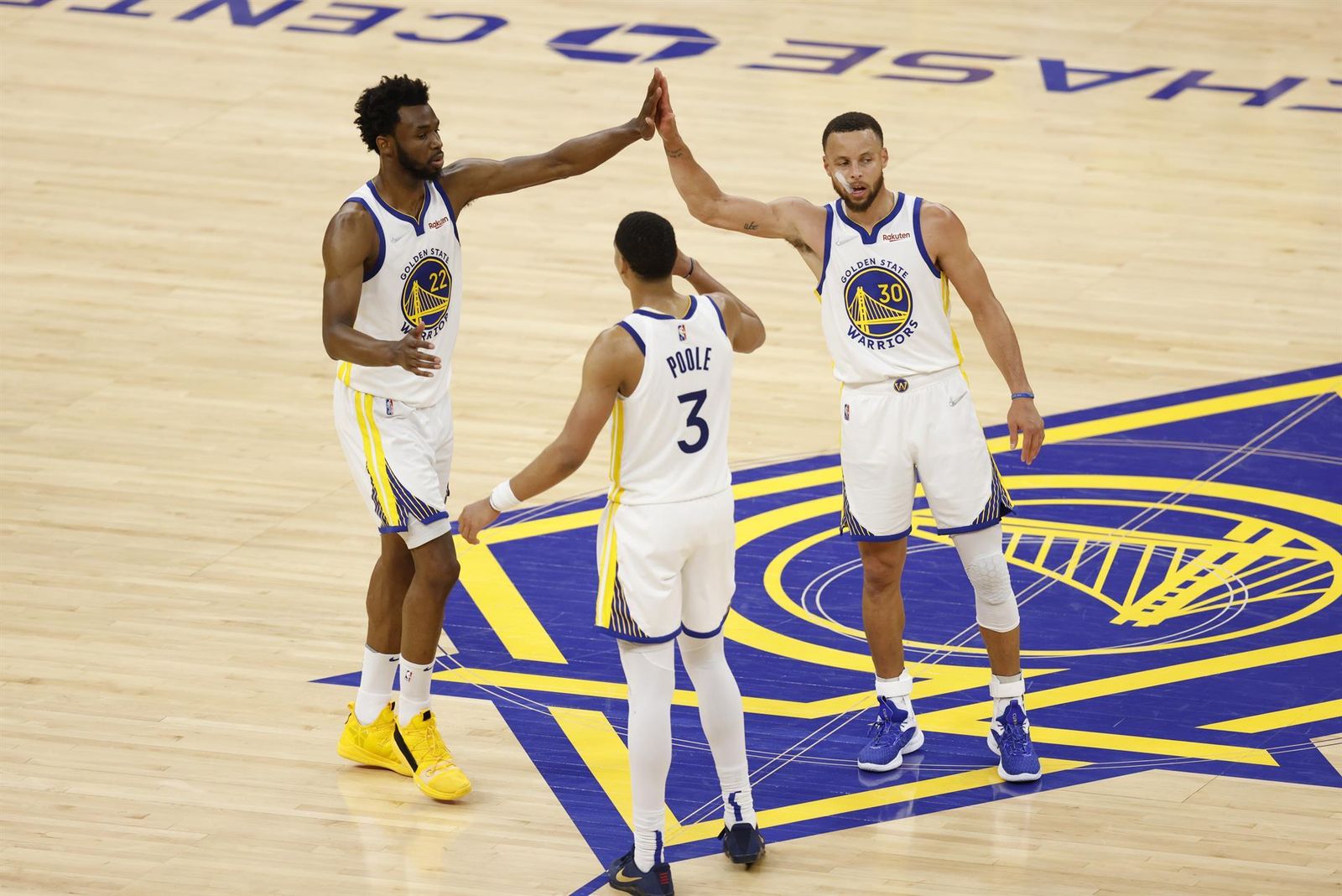 Curry celebra con dos compañeros la victoria.