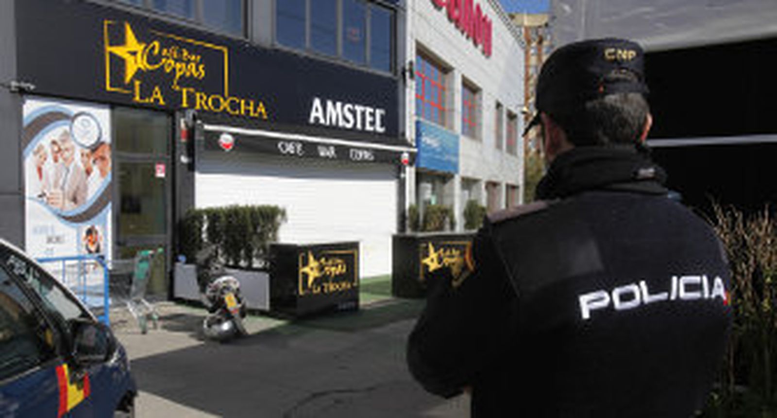 Un policía nacional monta guardia en la puerta del bar de copas La Trocha, la mañana del crimen. / José Ángel García
