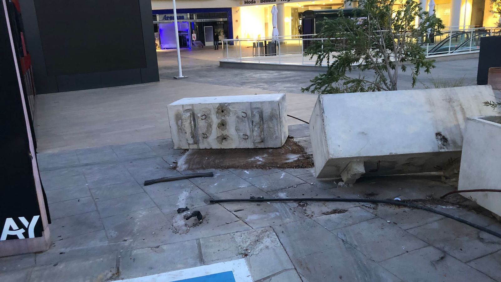 Las jardineras que tuvieron que ser retiradas para acceder con el coche hasta el establecimiento.