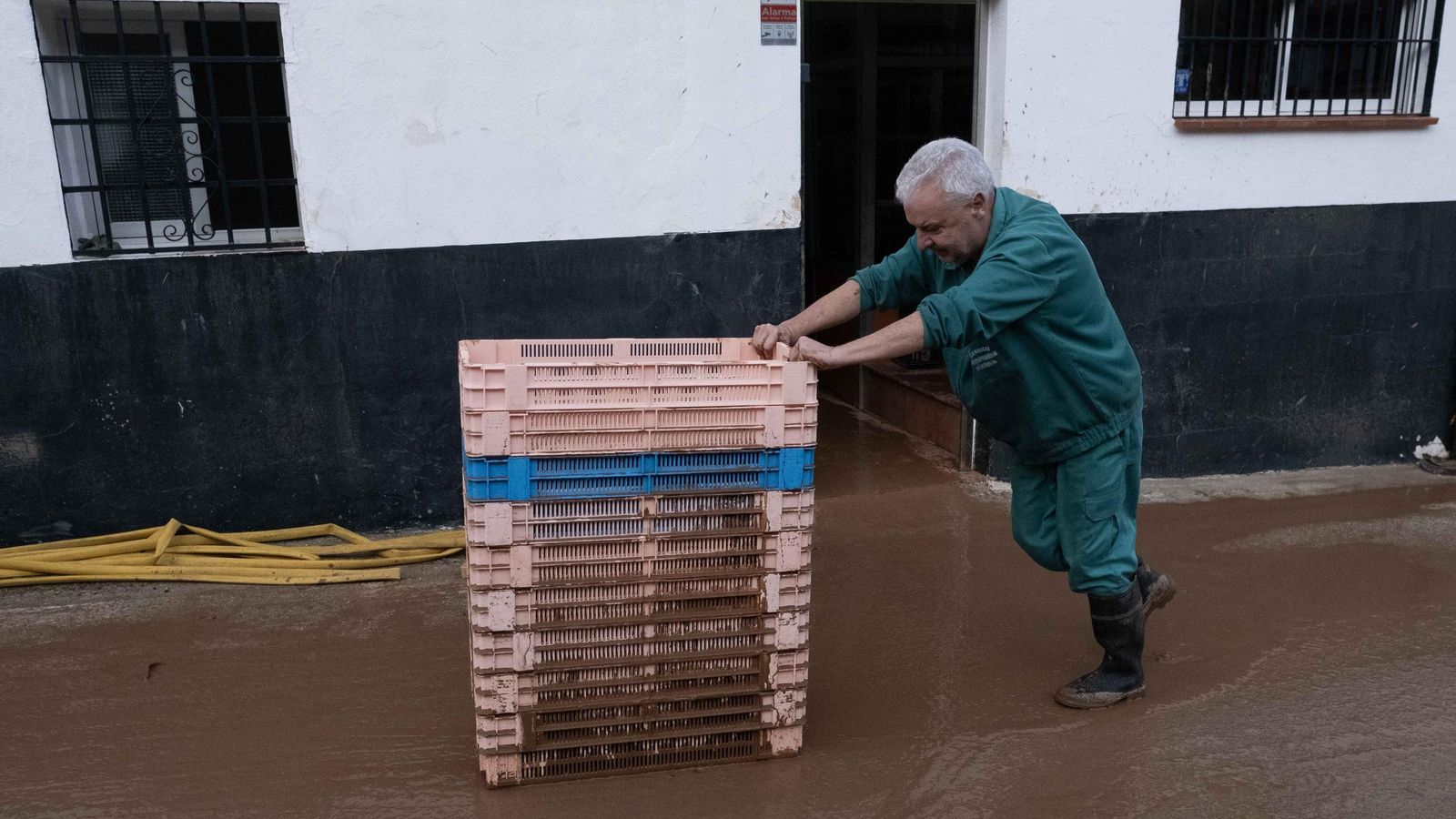 Trabajadores retiran las cajas alcanzadas por el lodo