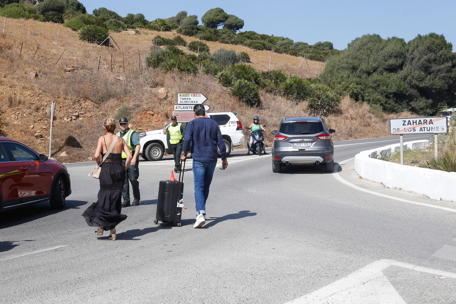 Turistas salen de Zahara con sus maletas.