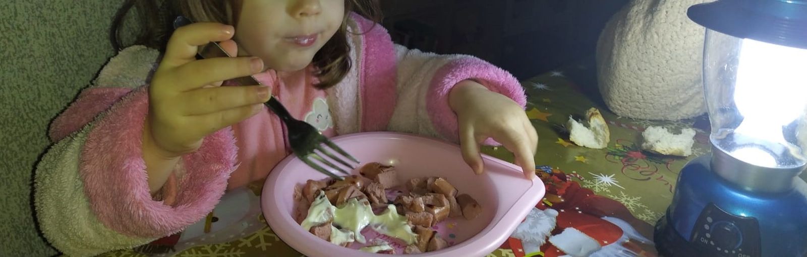 Una menor cenando a oscuras con velas