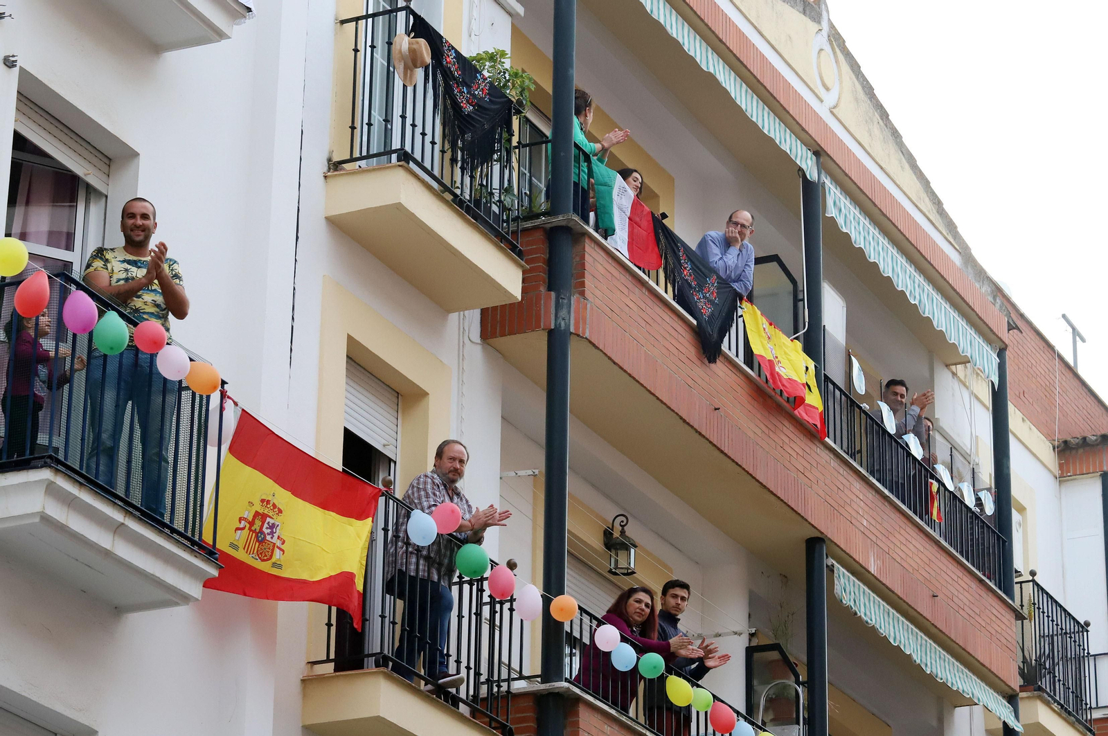 Varios vecinos de un bloque de viviendas aplauden a los profesionales sanitarios.