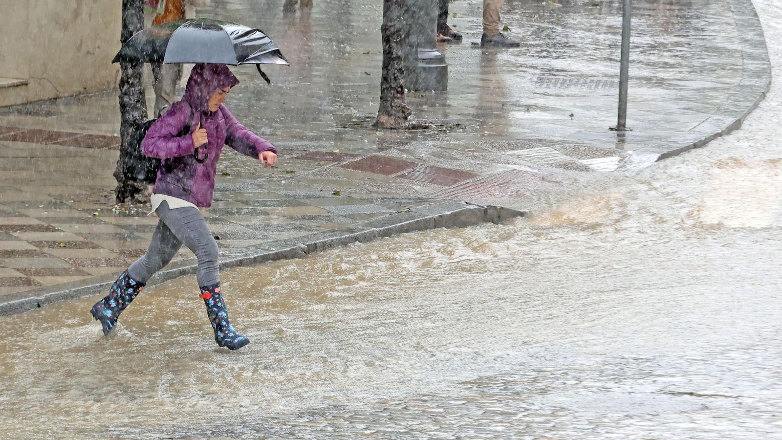Una mujer intenta evitar el agua durante las importantes lluvias caídas durante el pasado mes de marzo en Jerez.