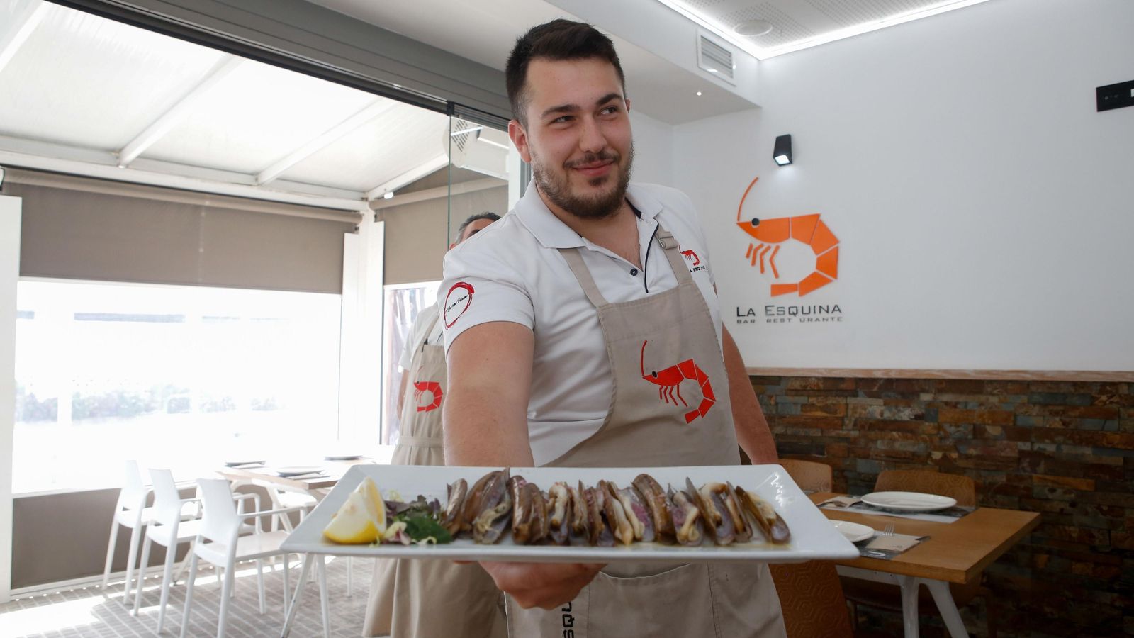 Un camarero de la Esquina muestra uno de sus platos.