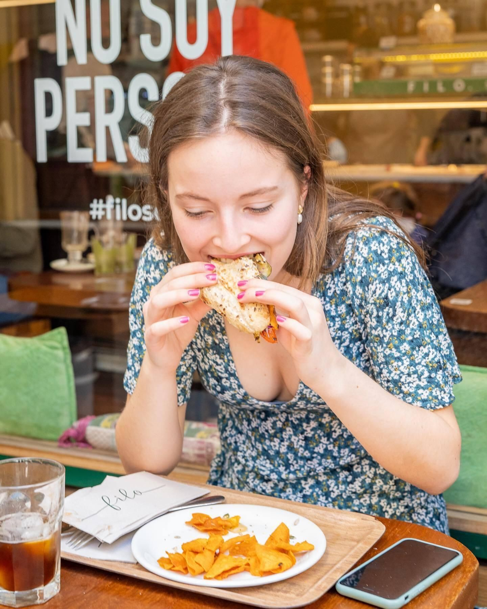 Una joven muerde uno de los sabroso emparedados de Filo.
