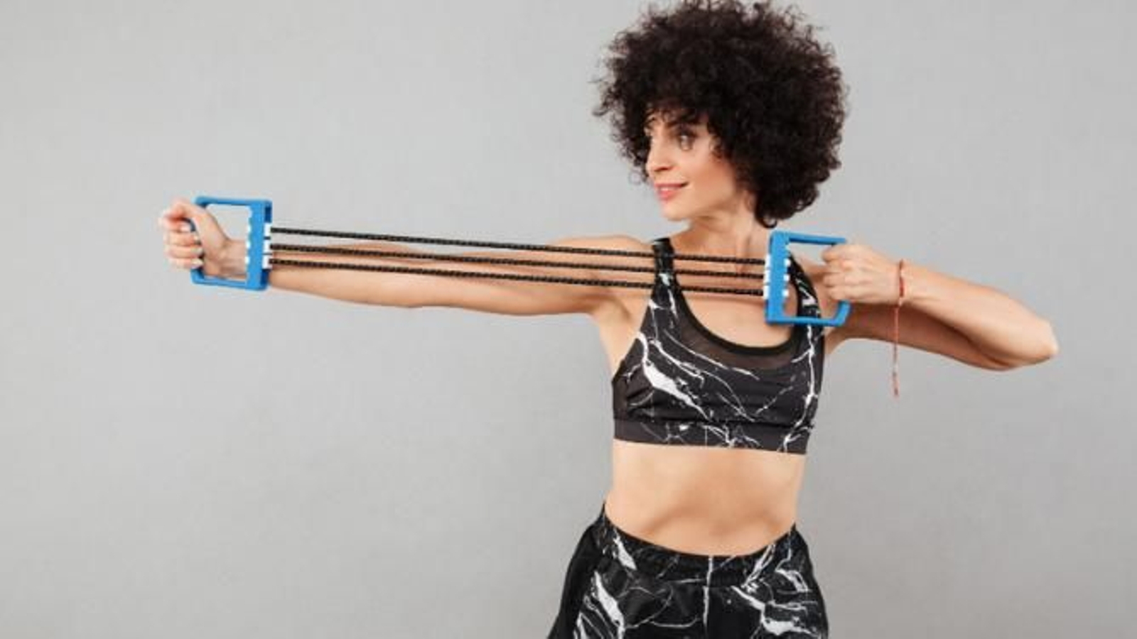 Mujer entrenando los brazos con banda elástica.