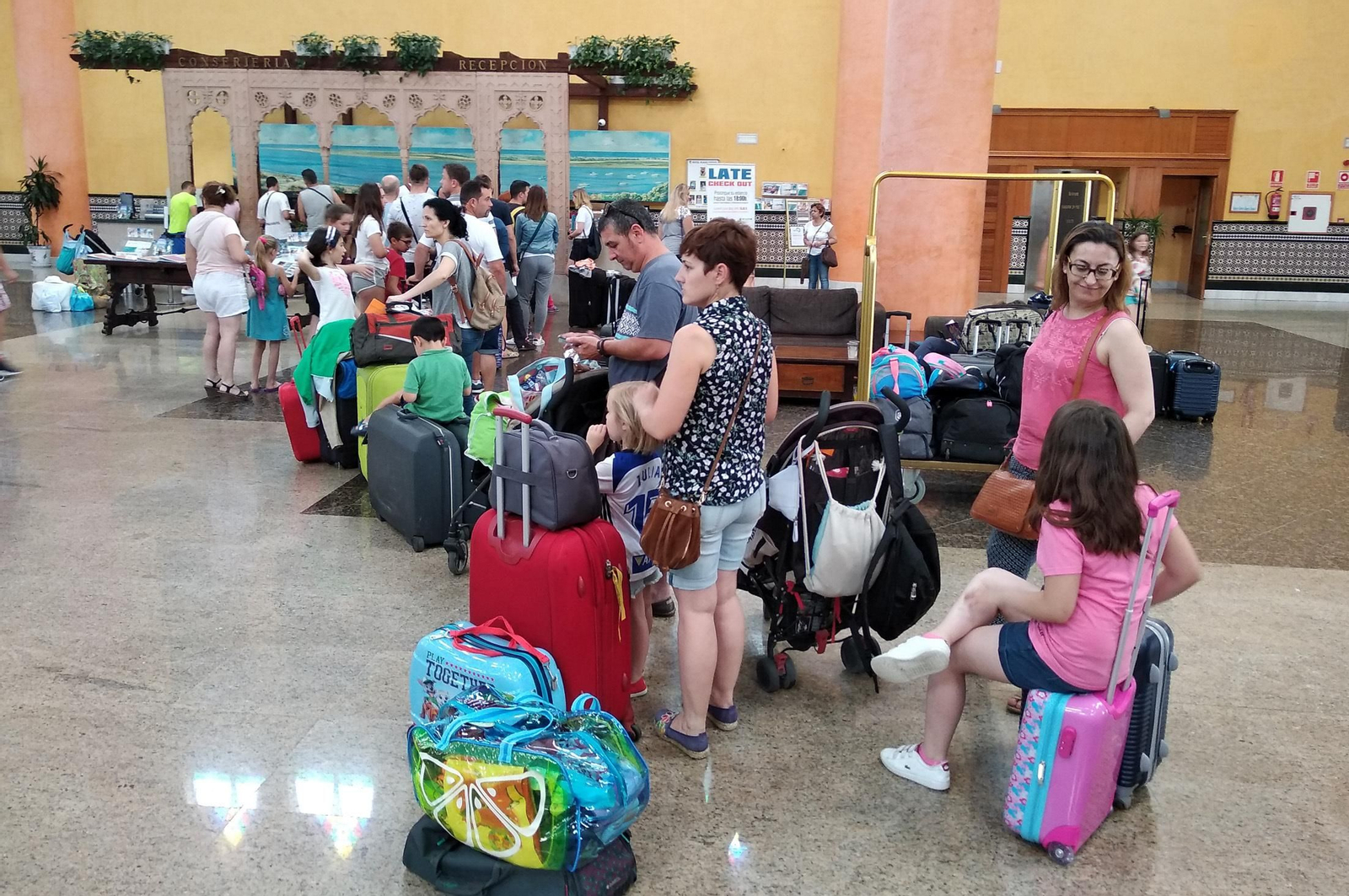 Una hilera de turistas esperan su turno en la recepción de un hotel del litoral onubense.