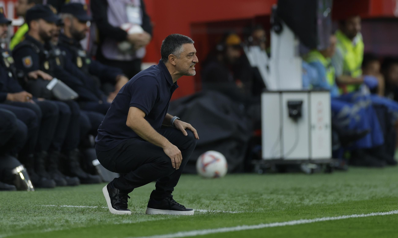 García Pimienta, en cuclillas, sigue el desarrollo del partido.