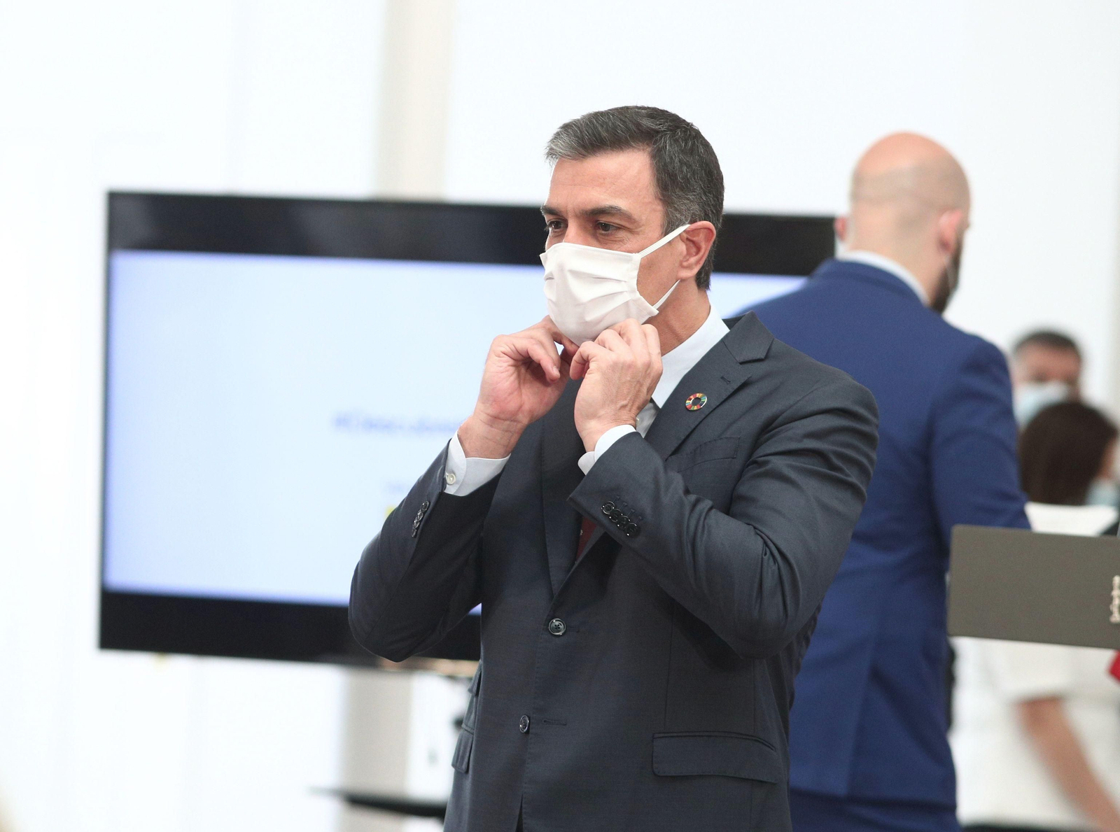 El presidente del Gobierno, Pedro Sánchez, se coloca un mascarilla.