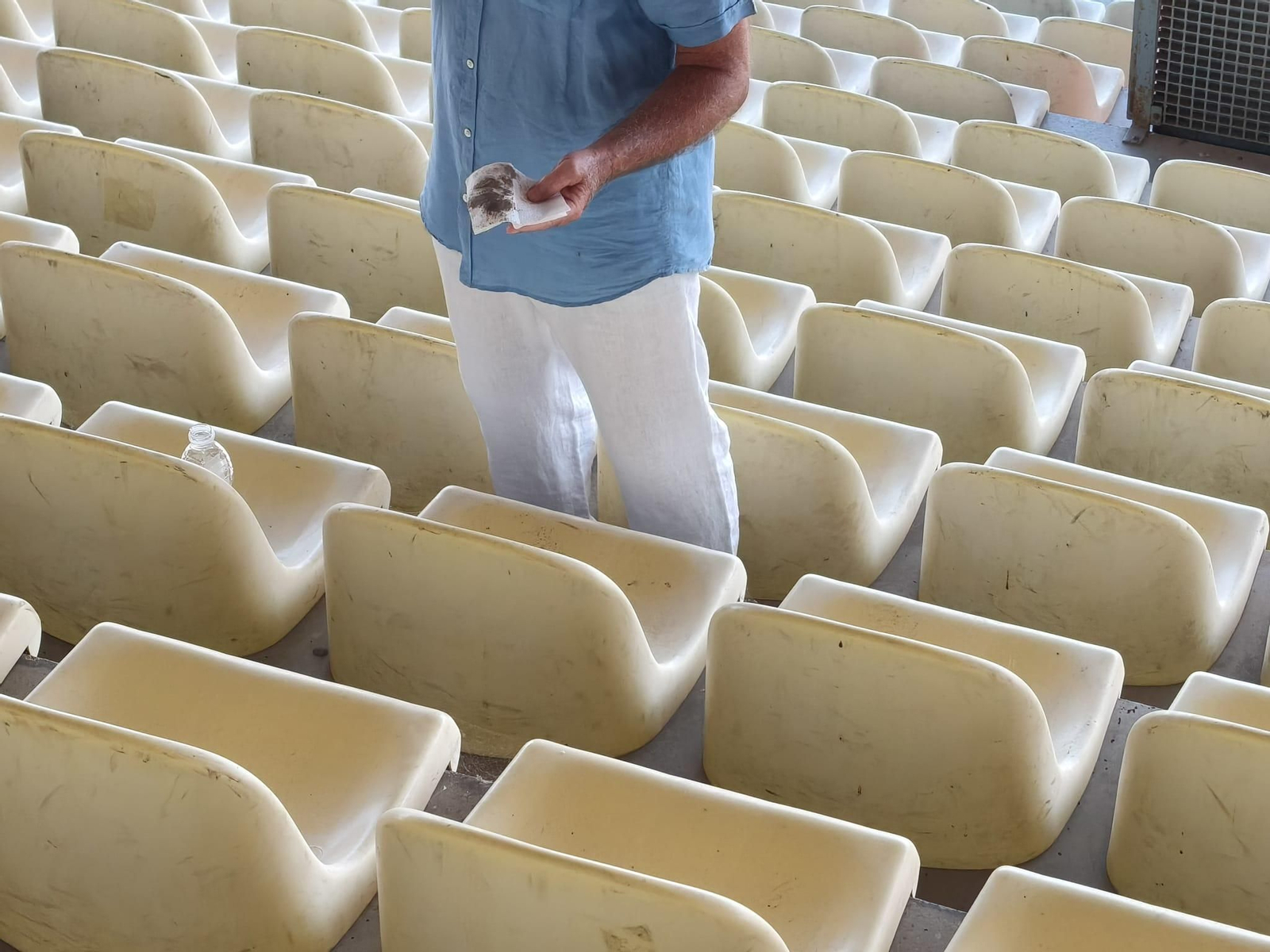 Un aficionado muestra la suciedad recogida de su asiento