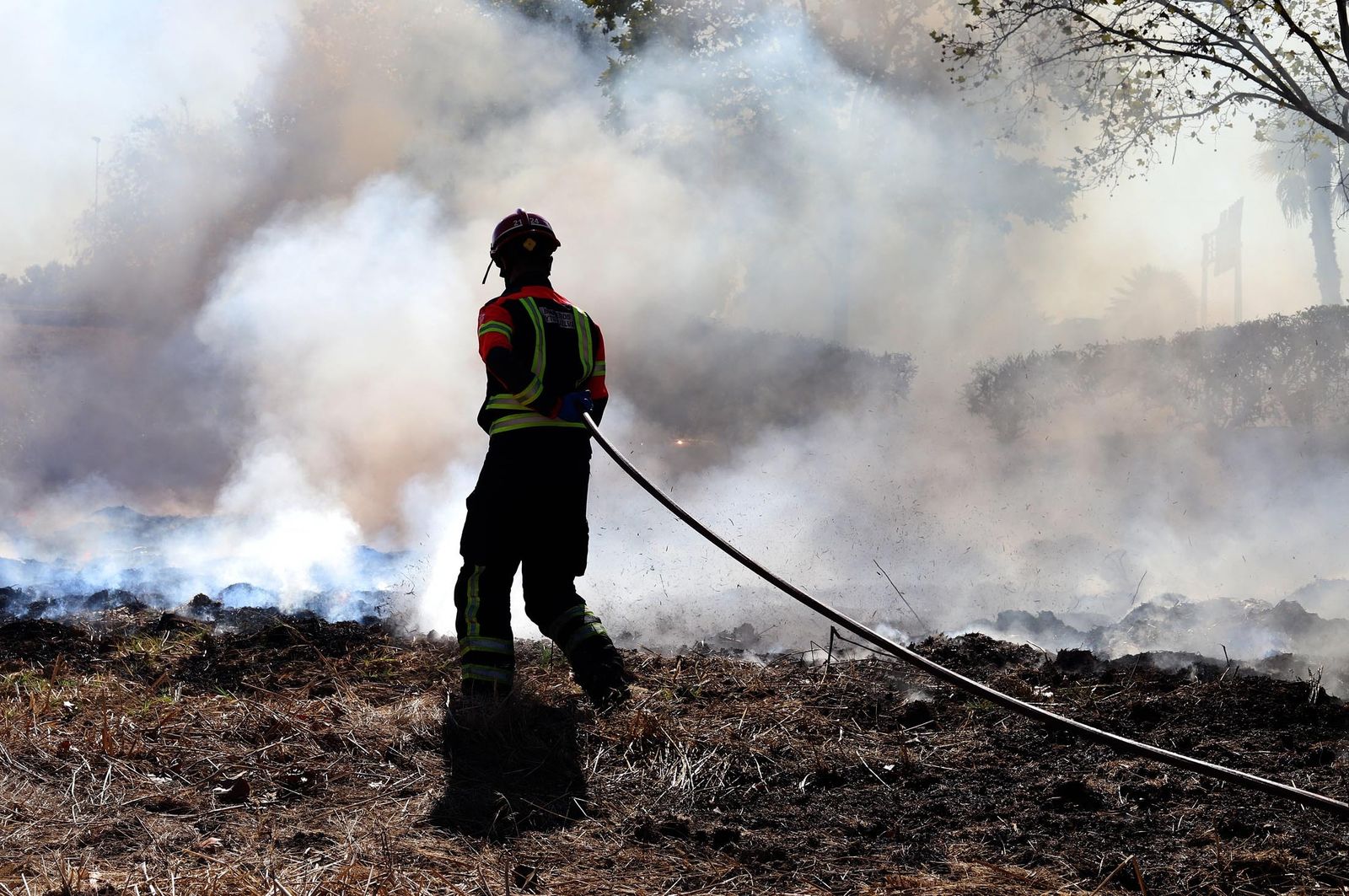Bombero sofocando las llamas en un incendio en Huelva