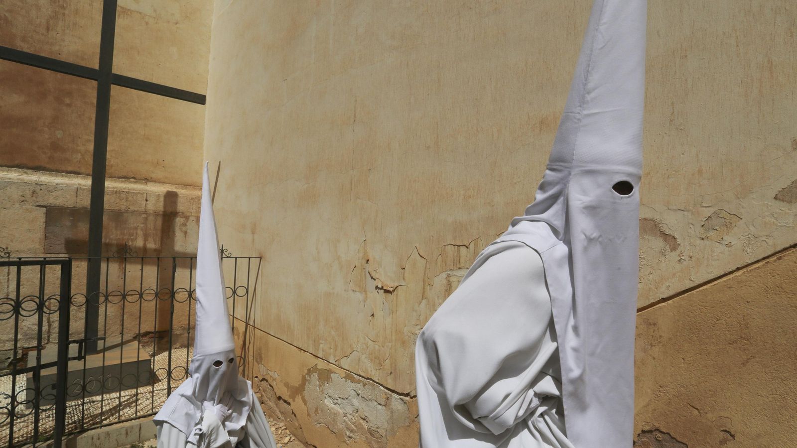Dos nazarenos de Salutación se preparan para salir de la iglesia de San Felipe Neri.