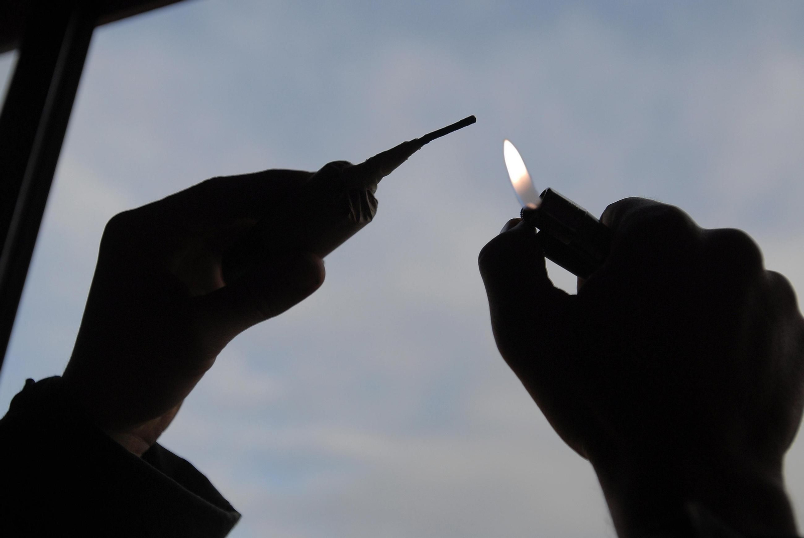 Una persona encendiendo un petardo.