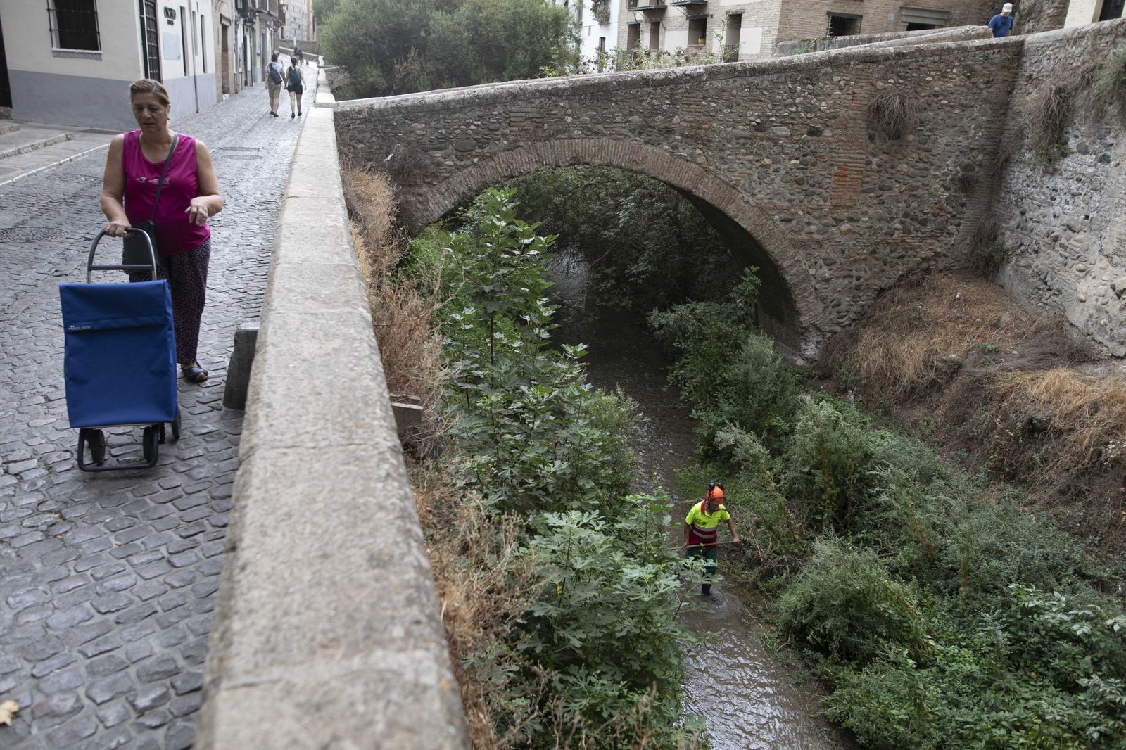 Una mujer paseo por el río Darro.