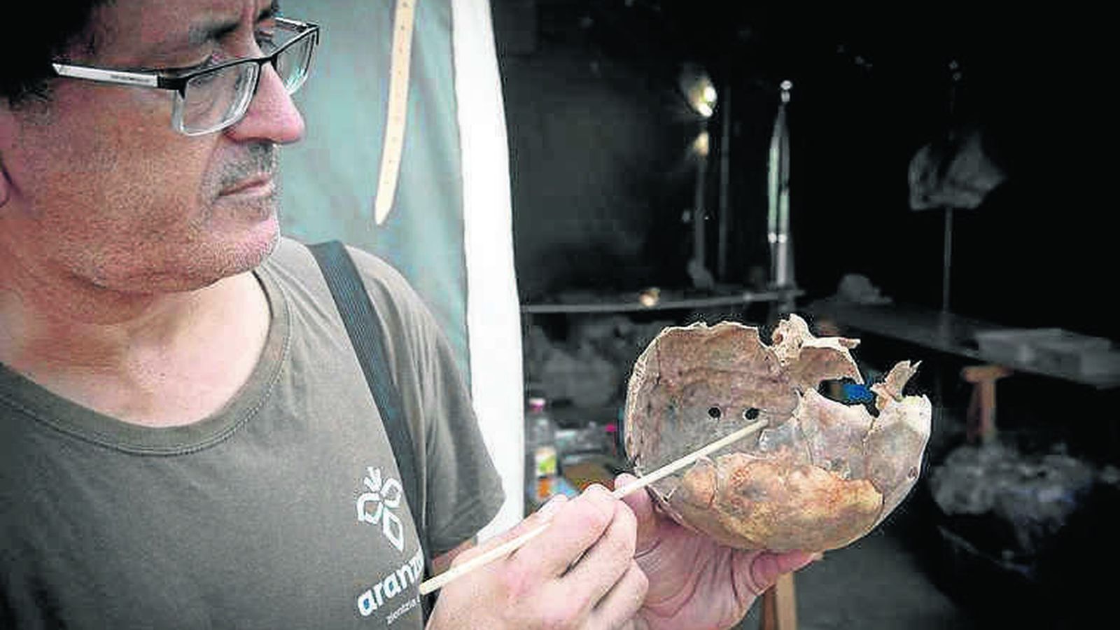 El antropólogo Juan Manuel Guijo mostrando un cráneo atravesado por una bala.