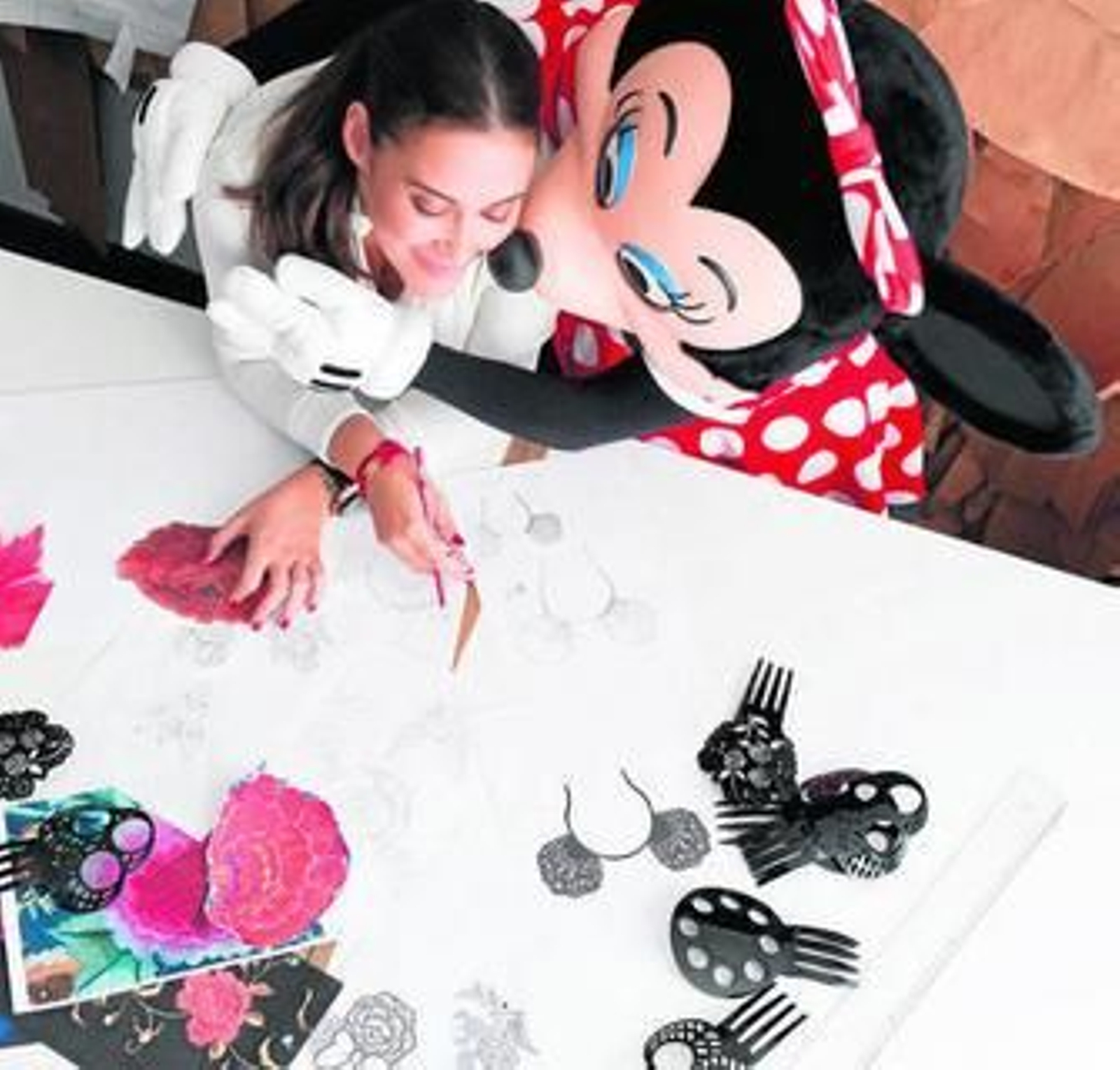 La diseñadora, con Minnie Mousse, viendo los diseños de la primera.