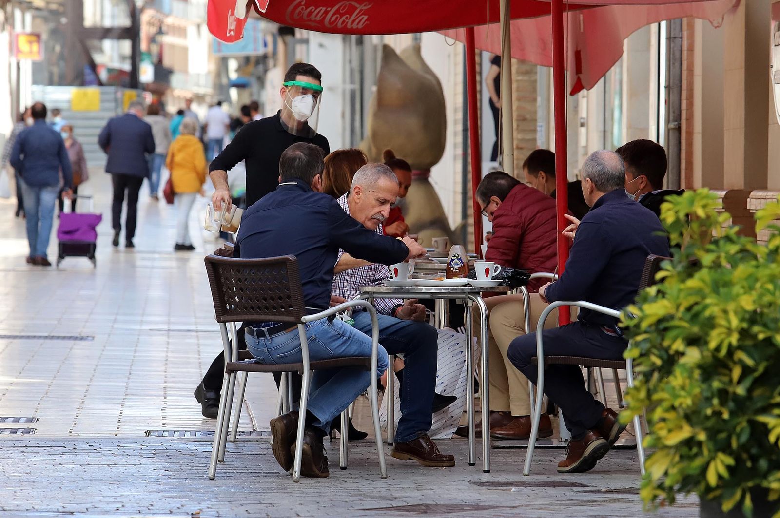 Grupos de clientes sentados en una terraza de un negocio de hostelería de Huelva.