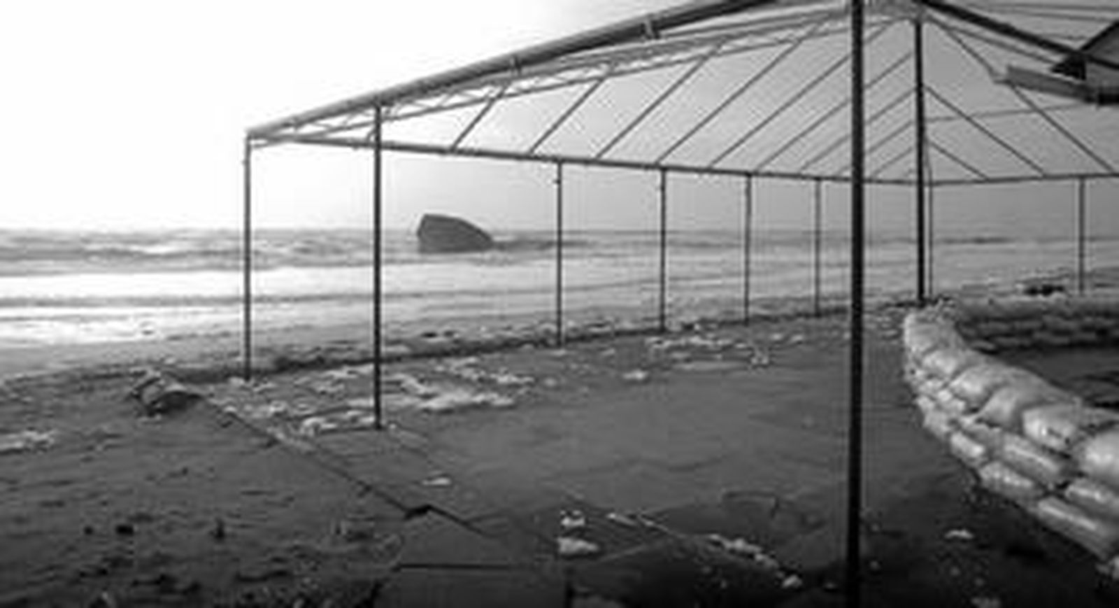 Un chiringuito de la playa de Matalascañas, ayer, protegido con sacos ante el avance del mar.