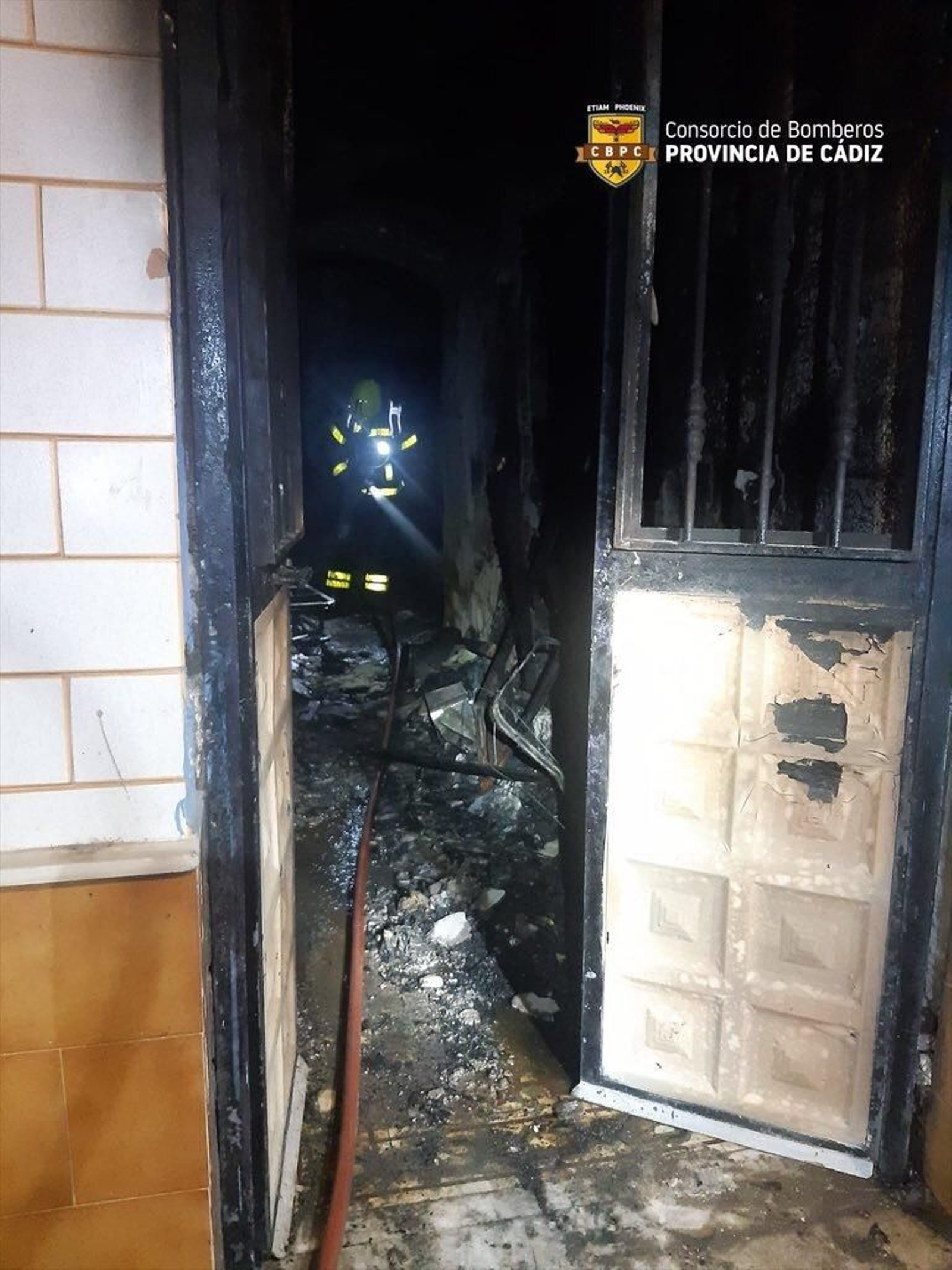 Un bombero accede a la casa incendiada.