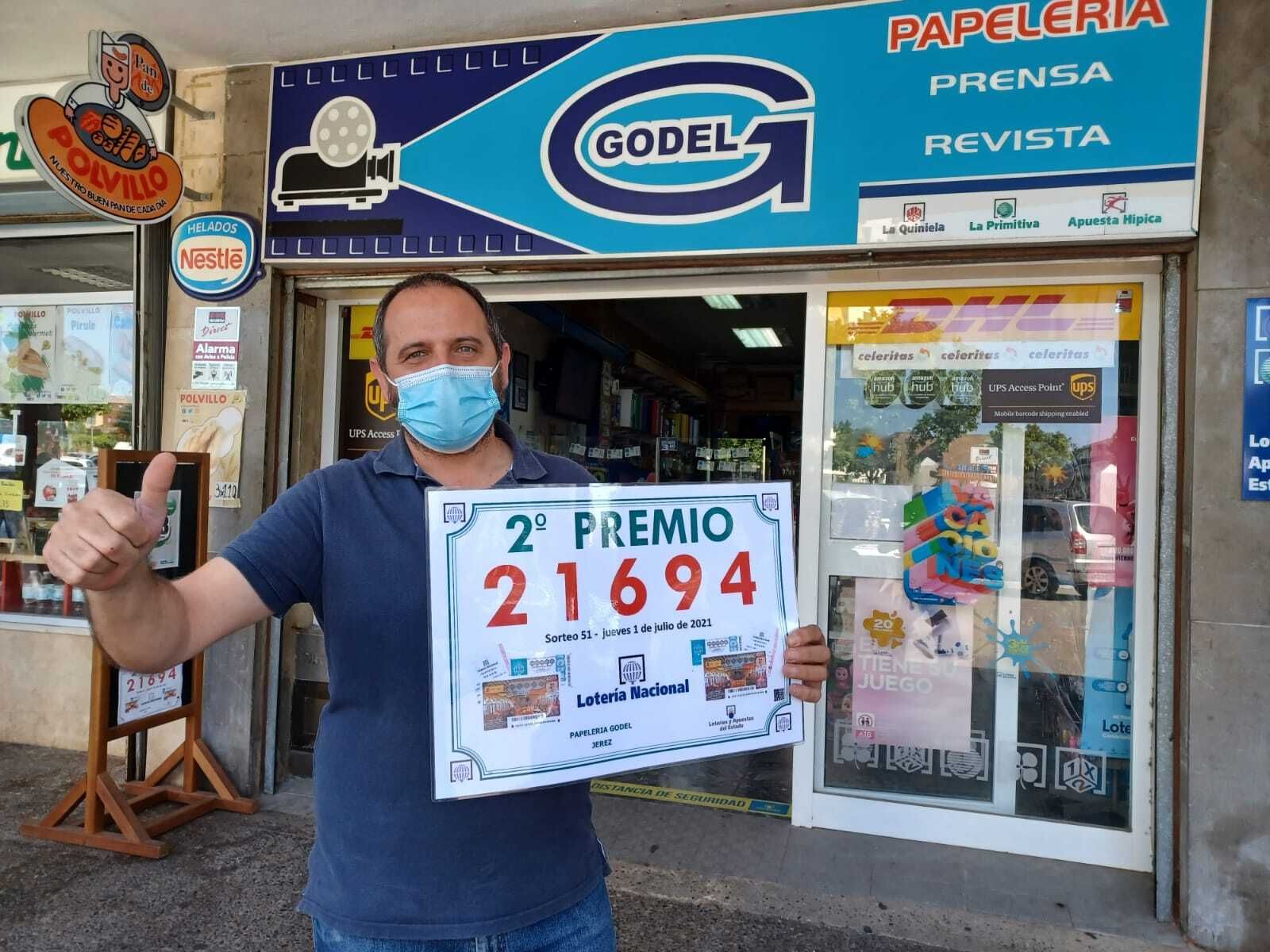 El administrador de la papelería Godel, Jorge Garzón, sostiene el segundo premio de la Lotería Nacional