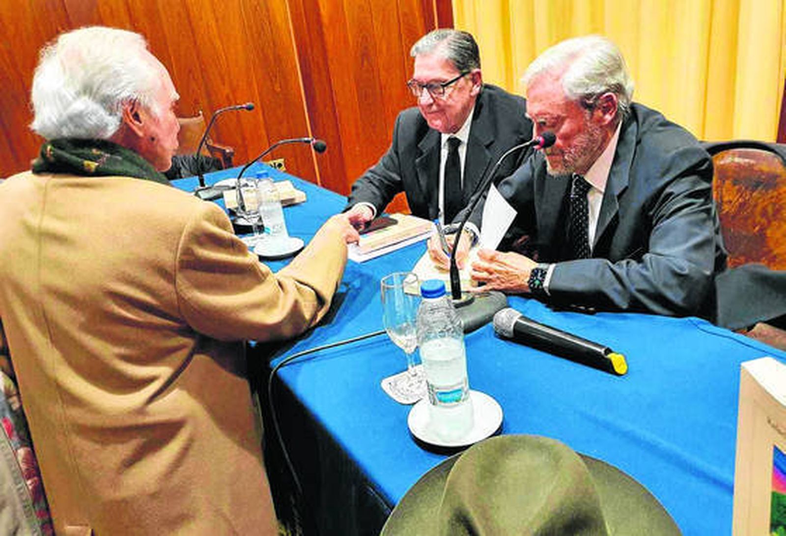 Rafael Moreno firma un ejemplar de su libro. A su izquierda, Antonio Crespo.