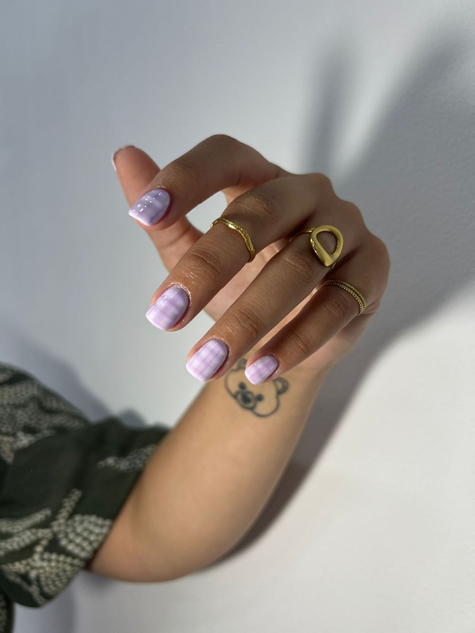 Manicura efecto damero en tonos lila.