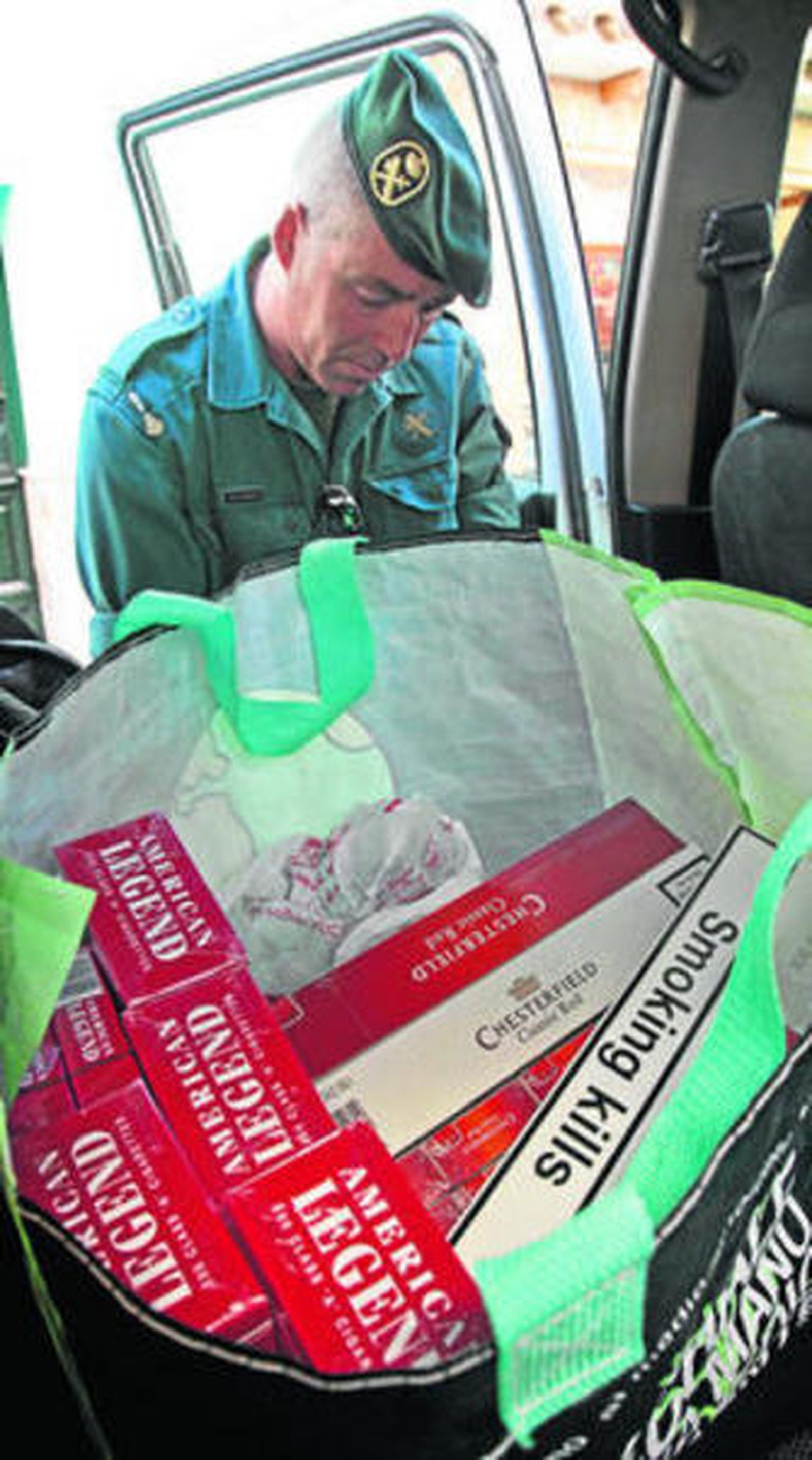 Un agente inspecciona un vehículo con tabaco de contrabando.