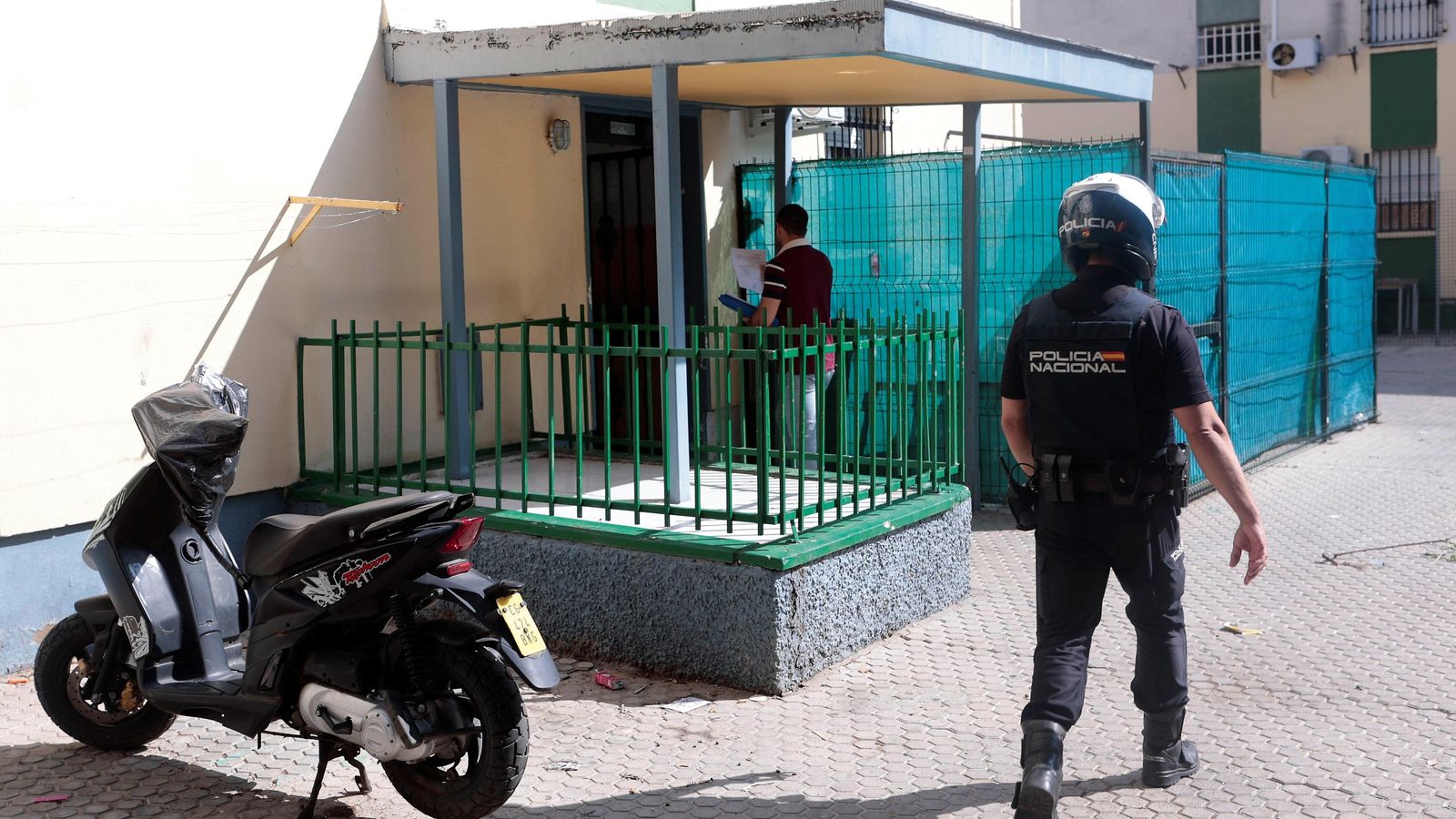 Un policía nacional acompaña a un funcionario a entregar una citación.