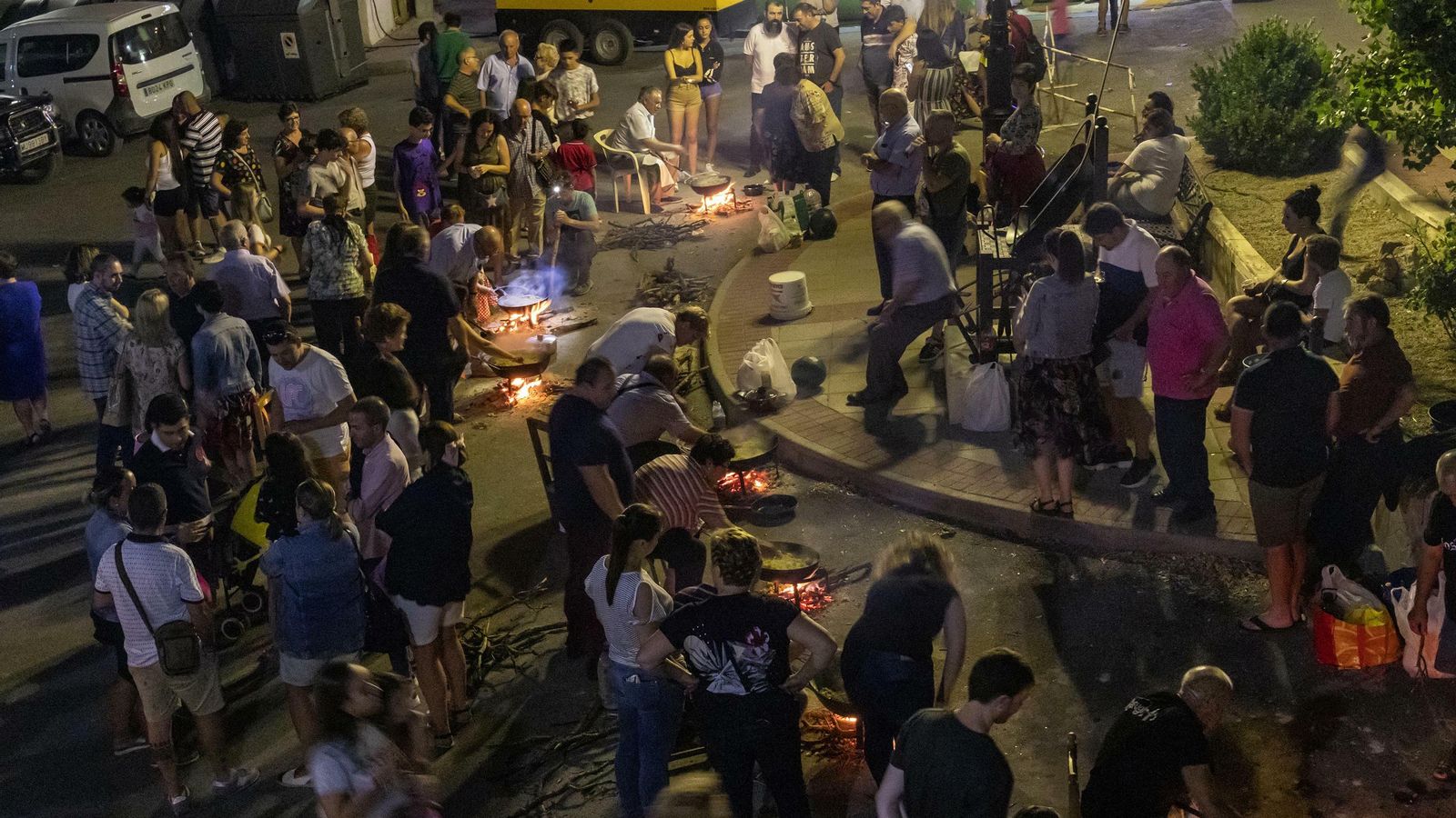 Decenas de personas se congregan en torno a las hogueras.