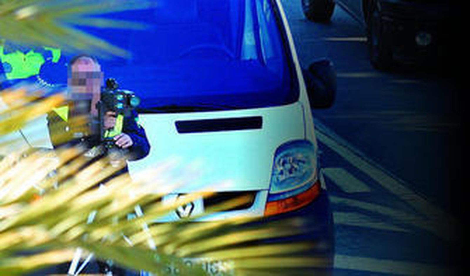 Un agente de la Policía Local con un radar móvil situado tras una patrullera en el paseo de Canalejas la pasada semana.