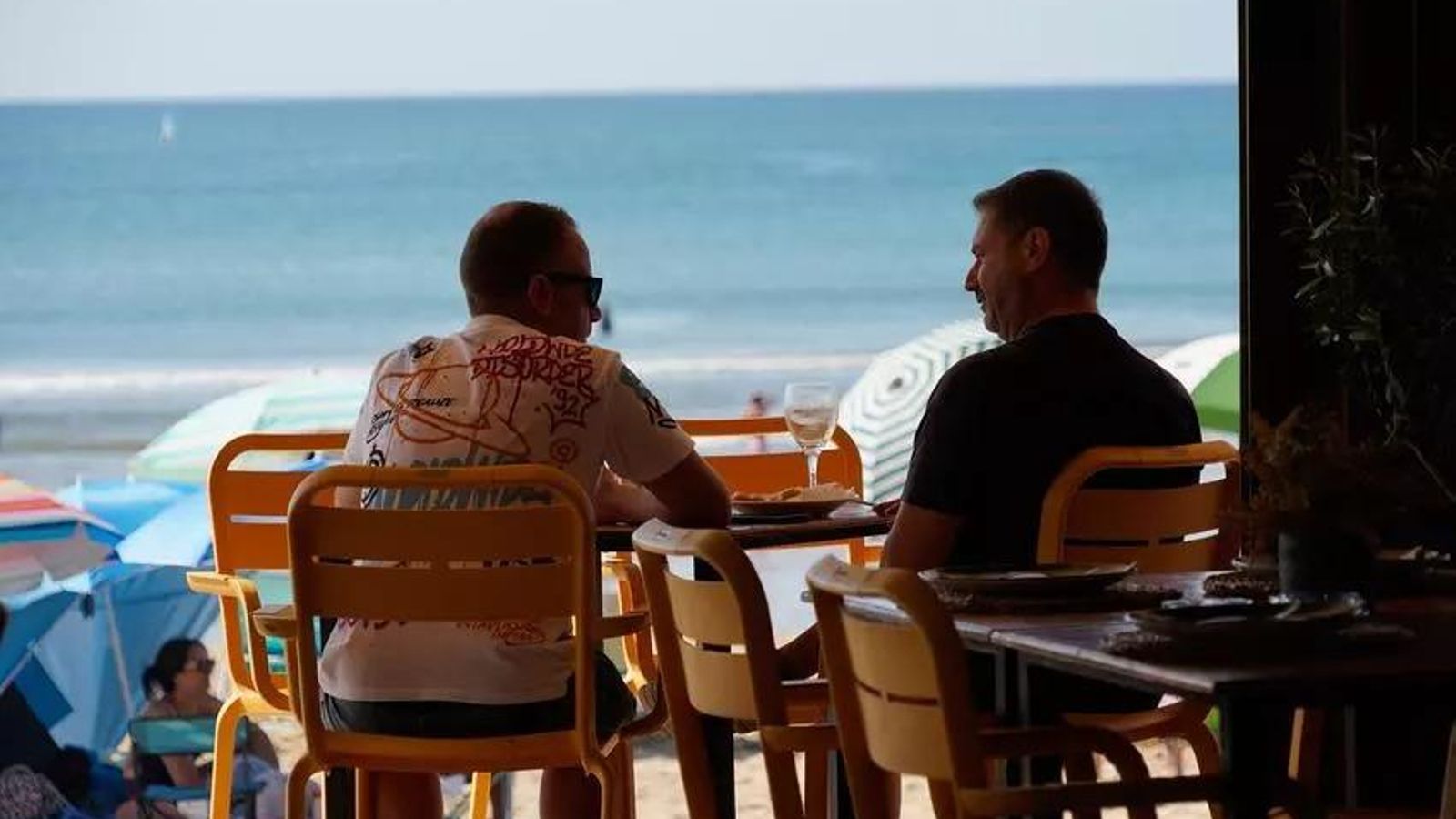 Dos hombres en un chiringuito en la palya de Isla Cristina.