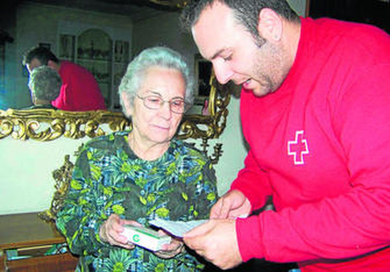Un trabajador de la Cruz Roja, atendiendo a una usuaria.