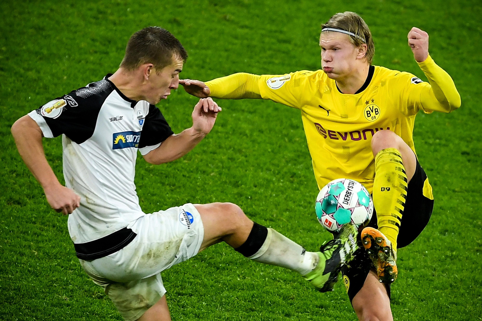 Haaland es entrado por Huenemeier en su intento de controlar un balón.