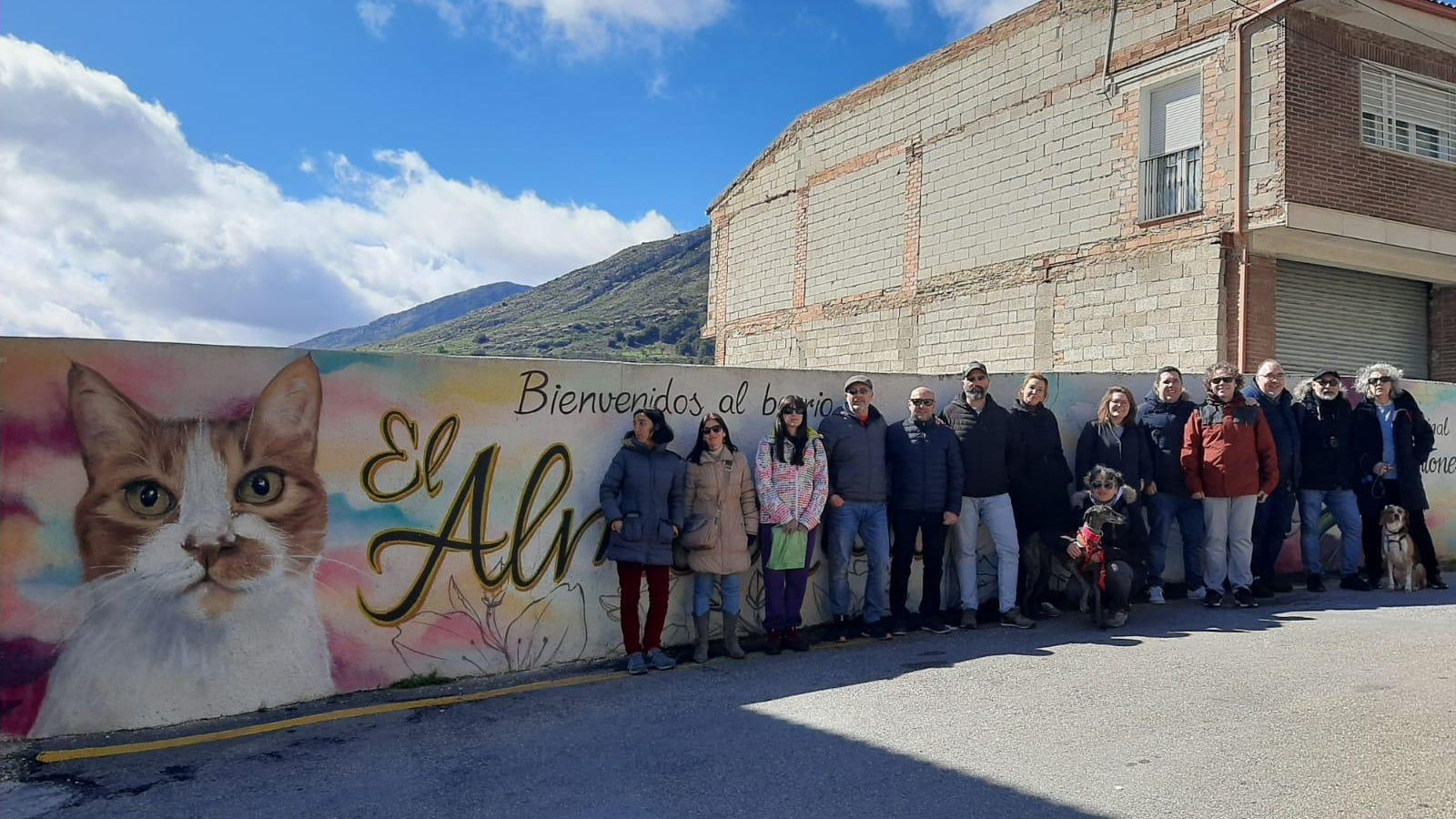 Miembros de la asociación posan en uno de los murales de El Almendral