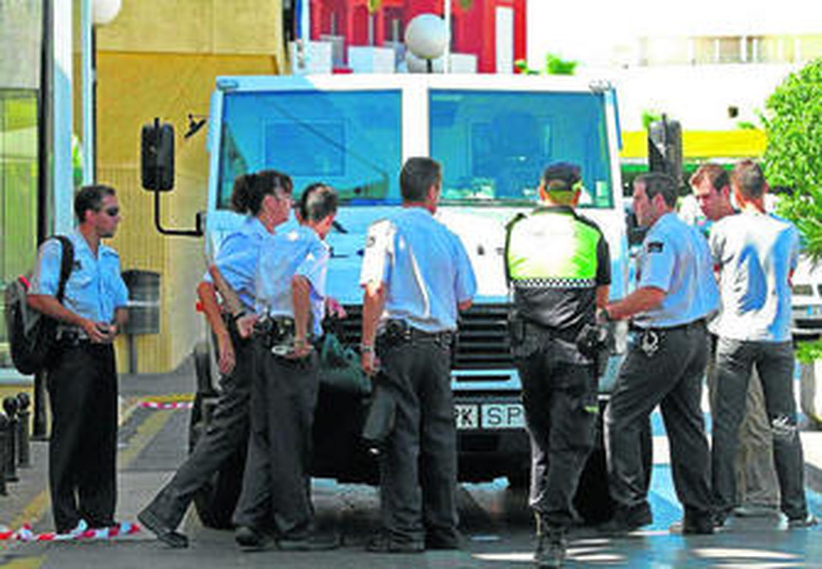 Policías y guardas jurados junto al camión blindado atracado ayer en Estepona.