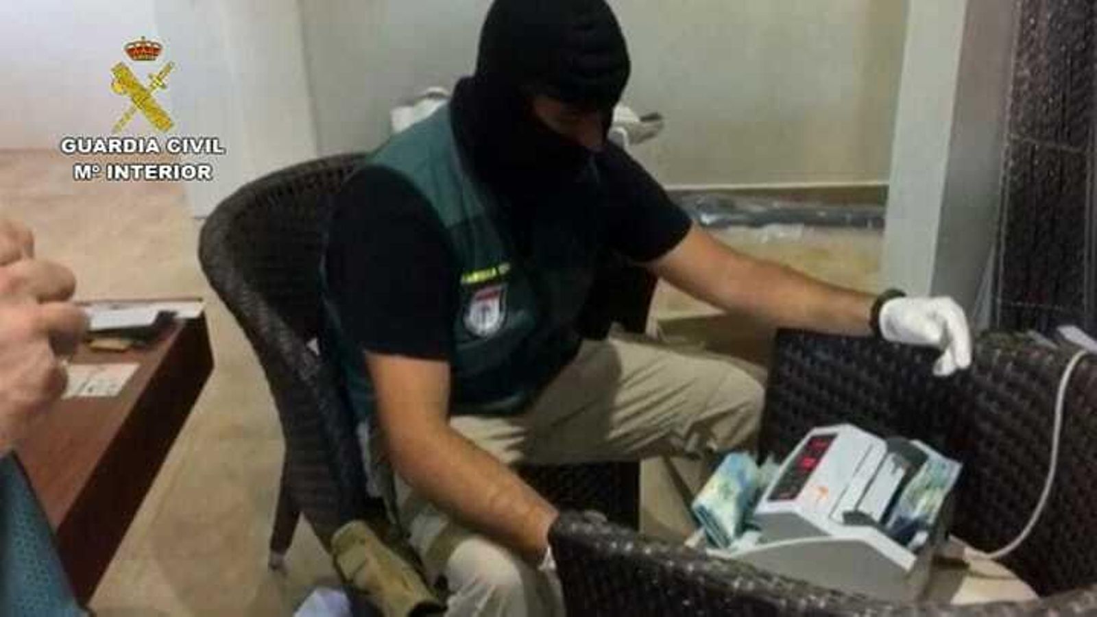 Un guardia civil, con la contadora de billetes.