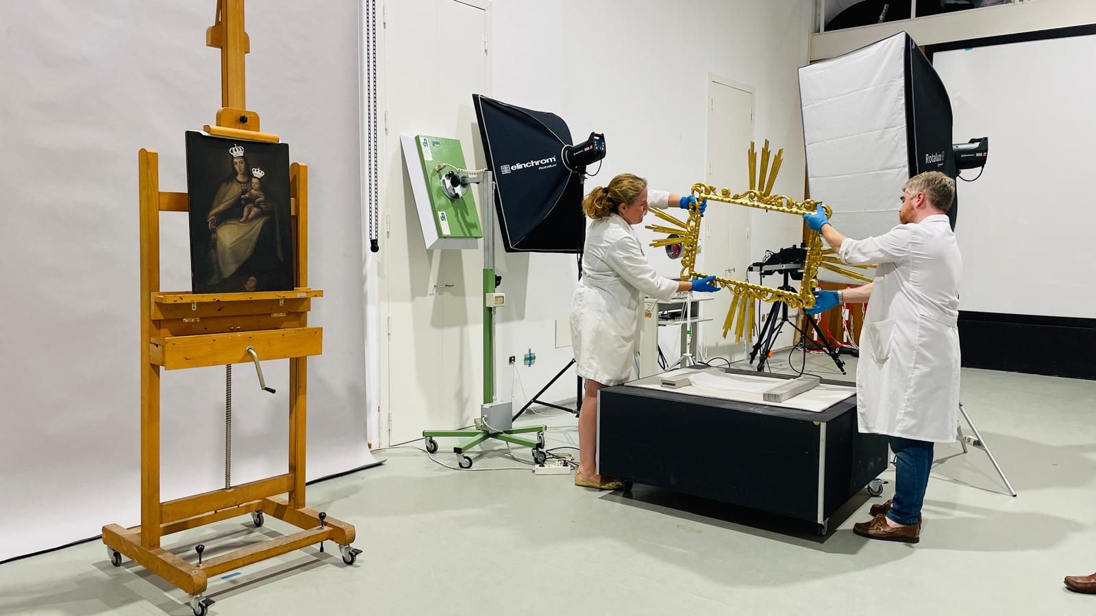 Los restauradores del IAPH manipulan el marco de la pintura.