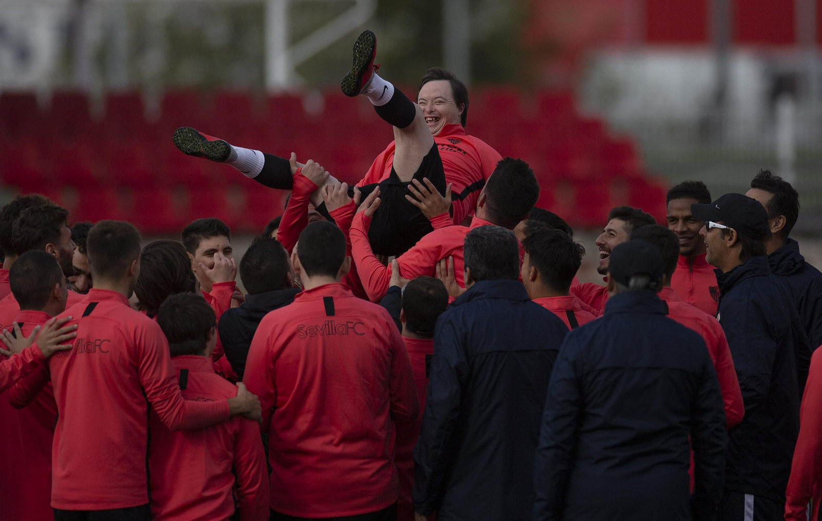 Los jugadores del Sevilla mantean a uno de los miembros del Sevilla Genuine.