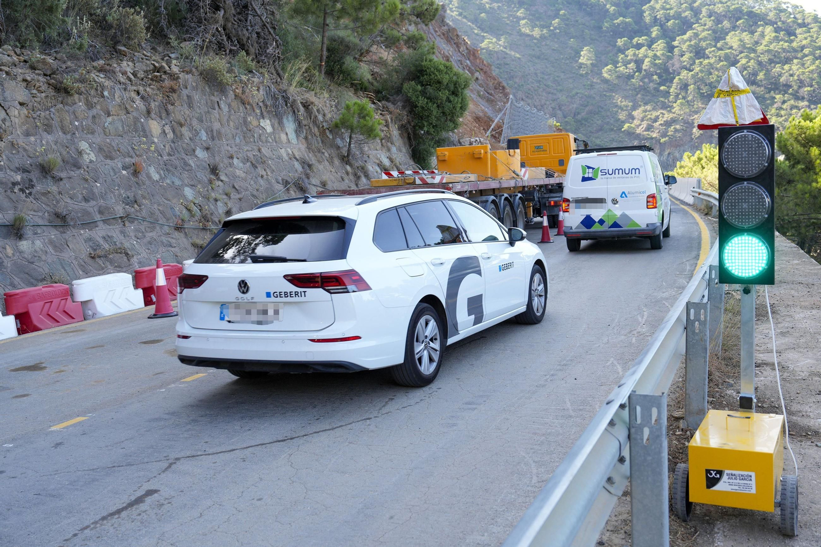 Coches pasan por el semáforo de la carretera entre Ronda y San Pedro.