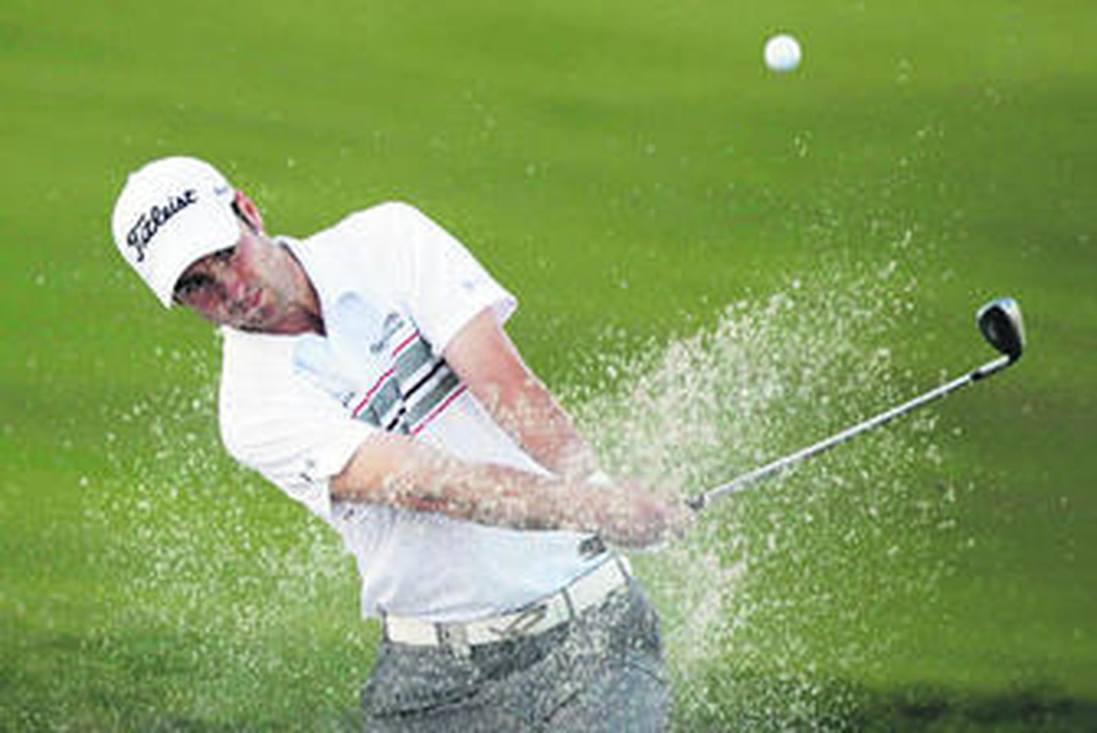 Ross Fisher golpea la bola en el 'bunker' del hoyo 15.