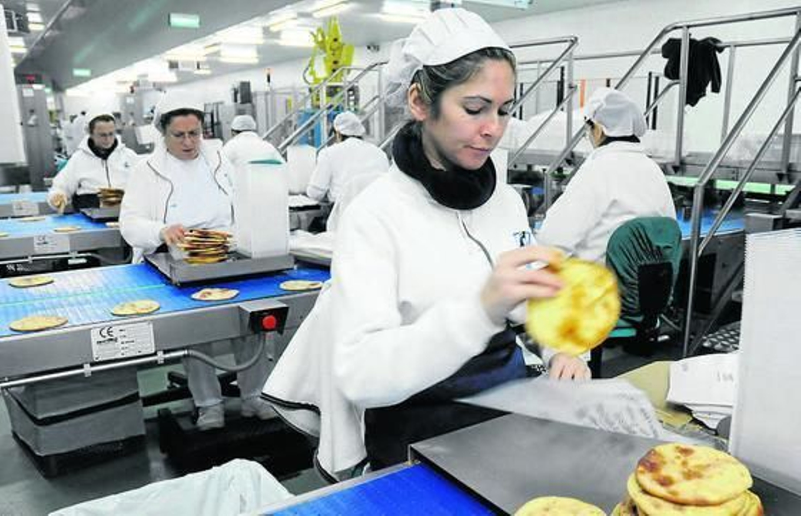Proceso de envasado de tortas de aceite de Castilleja de la Cuesta. / JUAN CARLOS VÁZQUEZ