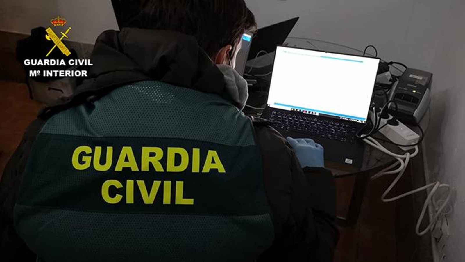 Un agente analiza el ordenador del sospechoso.