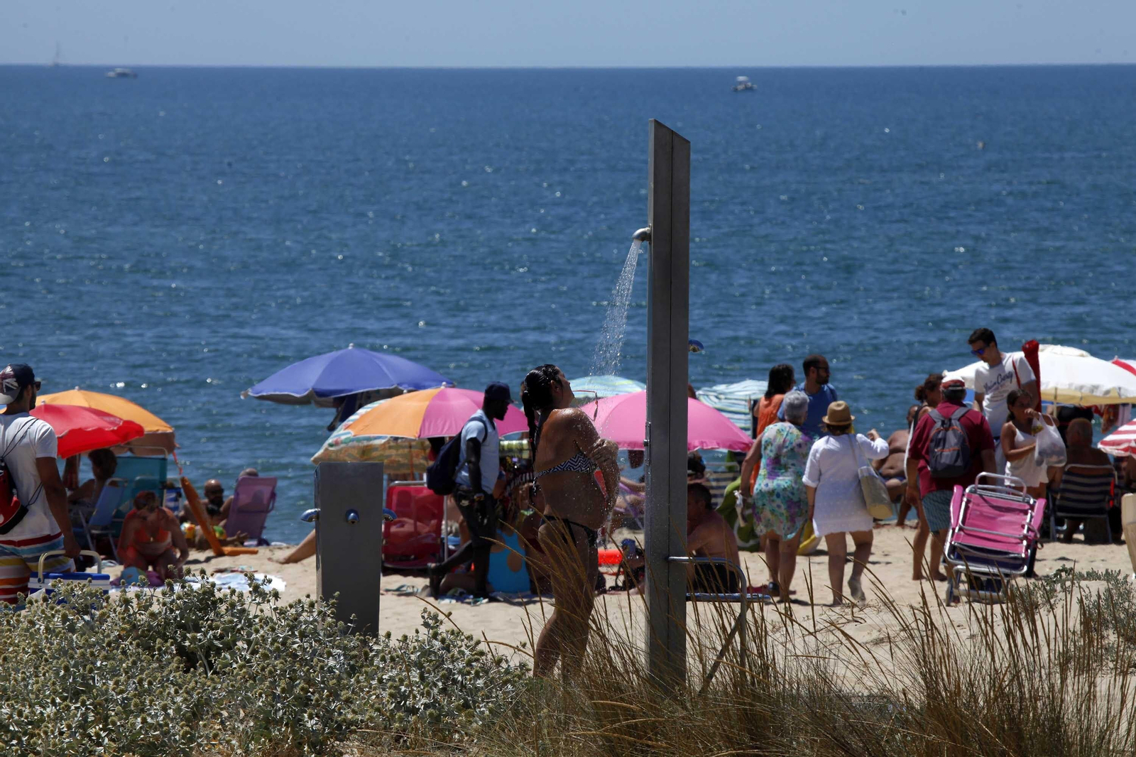 Una mujer toma una ducha en una playa onubense. Una mujer toma una ducha en una playa onubense.